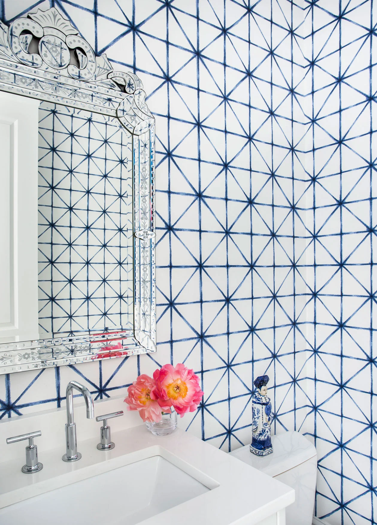 Blue and white geometric wallpaper in powder room
