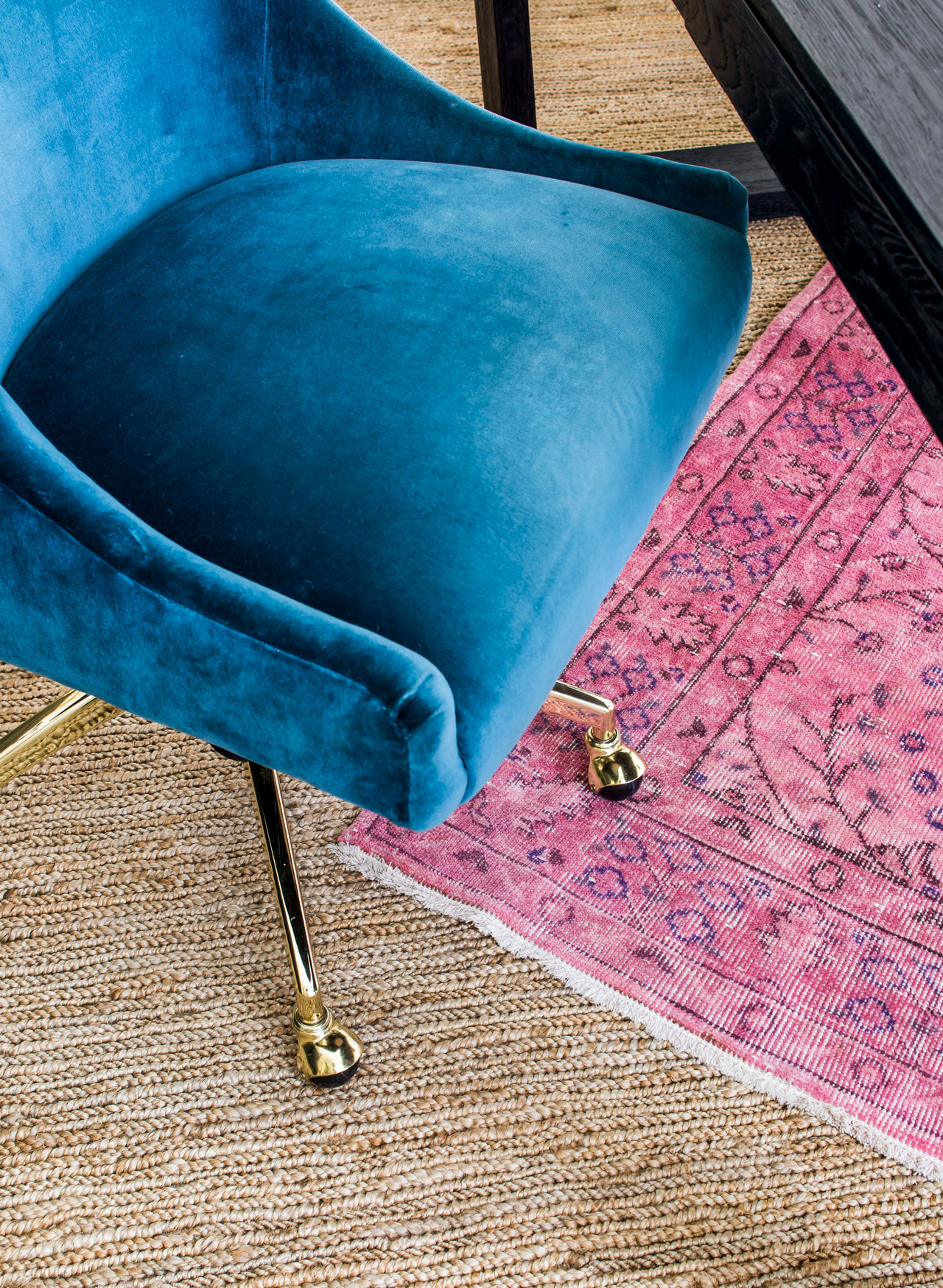 Velvet upholstered desk chair on layered jute and pink area rugs in home office