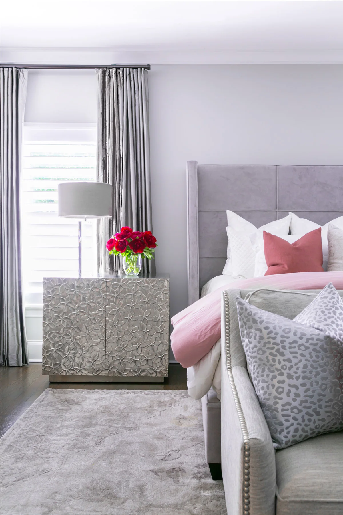 Chic contemporary master bedroom with silver floral embossed nightstands and pink bedding