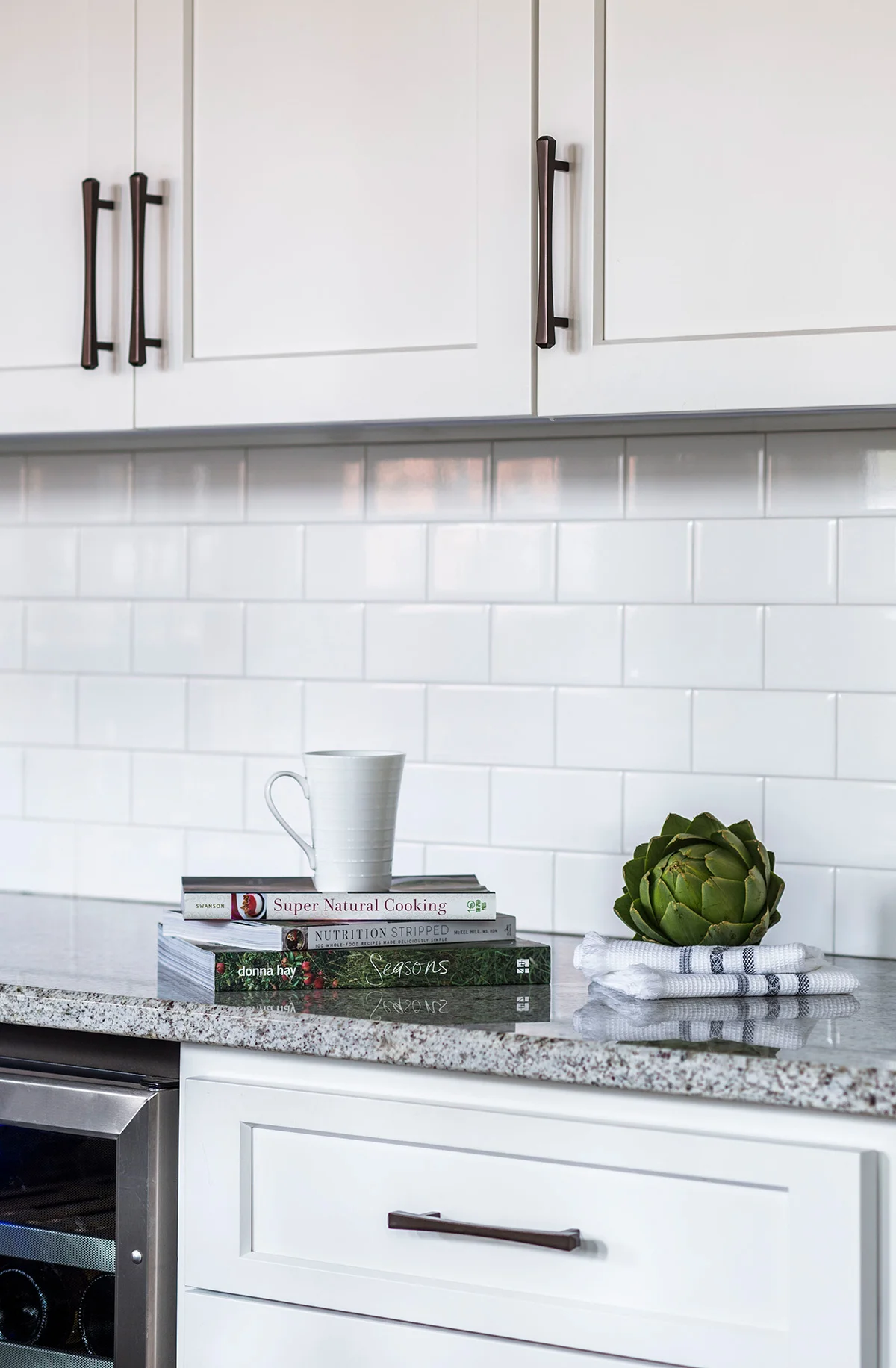 Cookbooks sit on grey granite countertops in kitchen