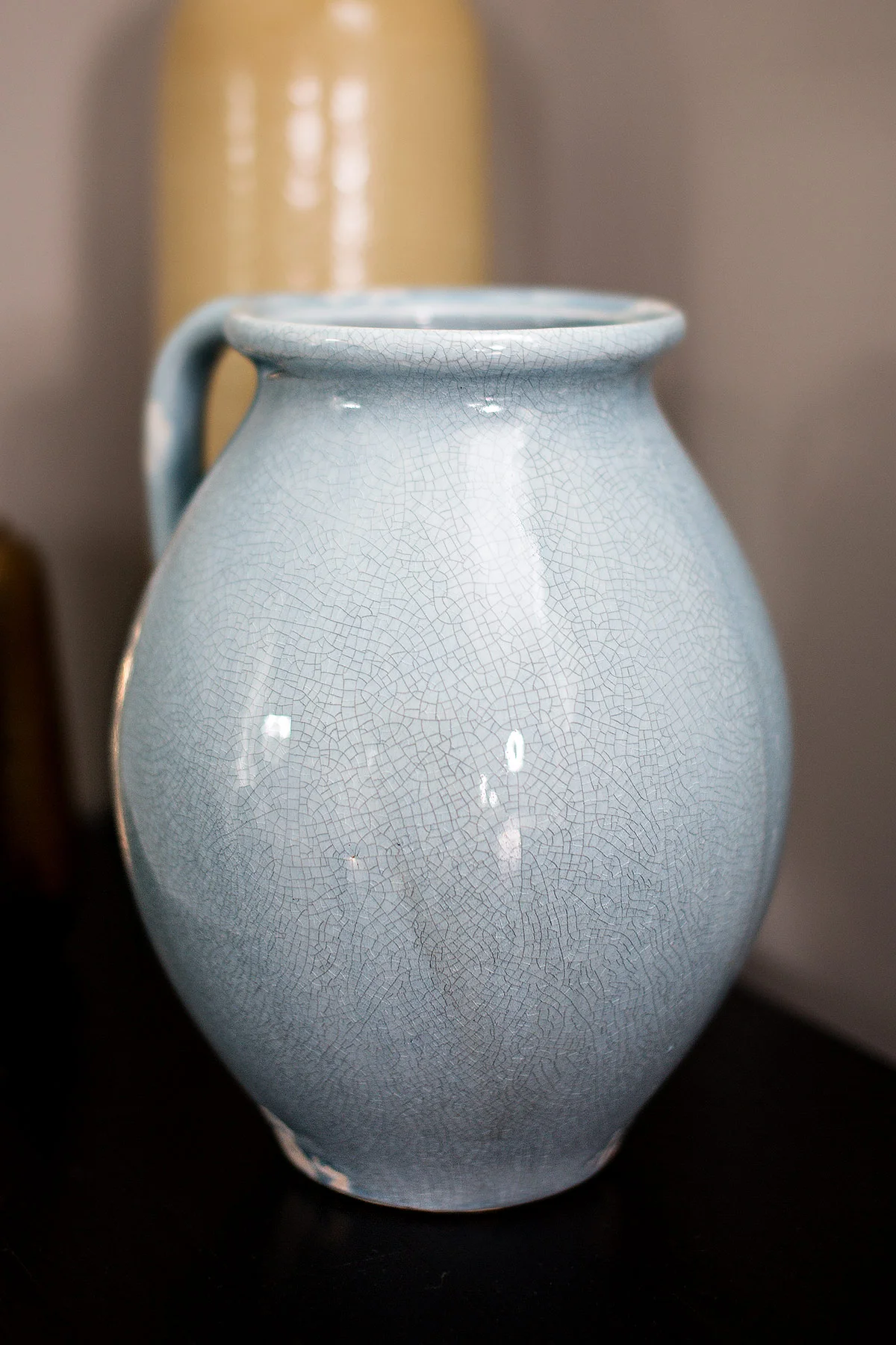 Blue vase on top of wood dresser