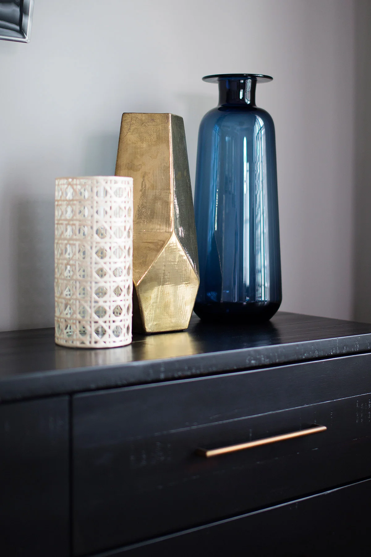 Three vases on top of espresso wood dresser