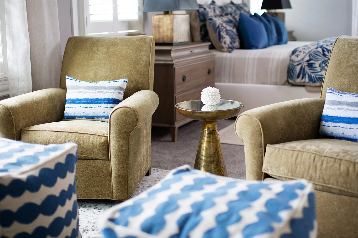 Upholstered chairs in sitting area in transitional master bedroom