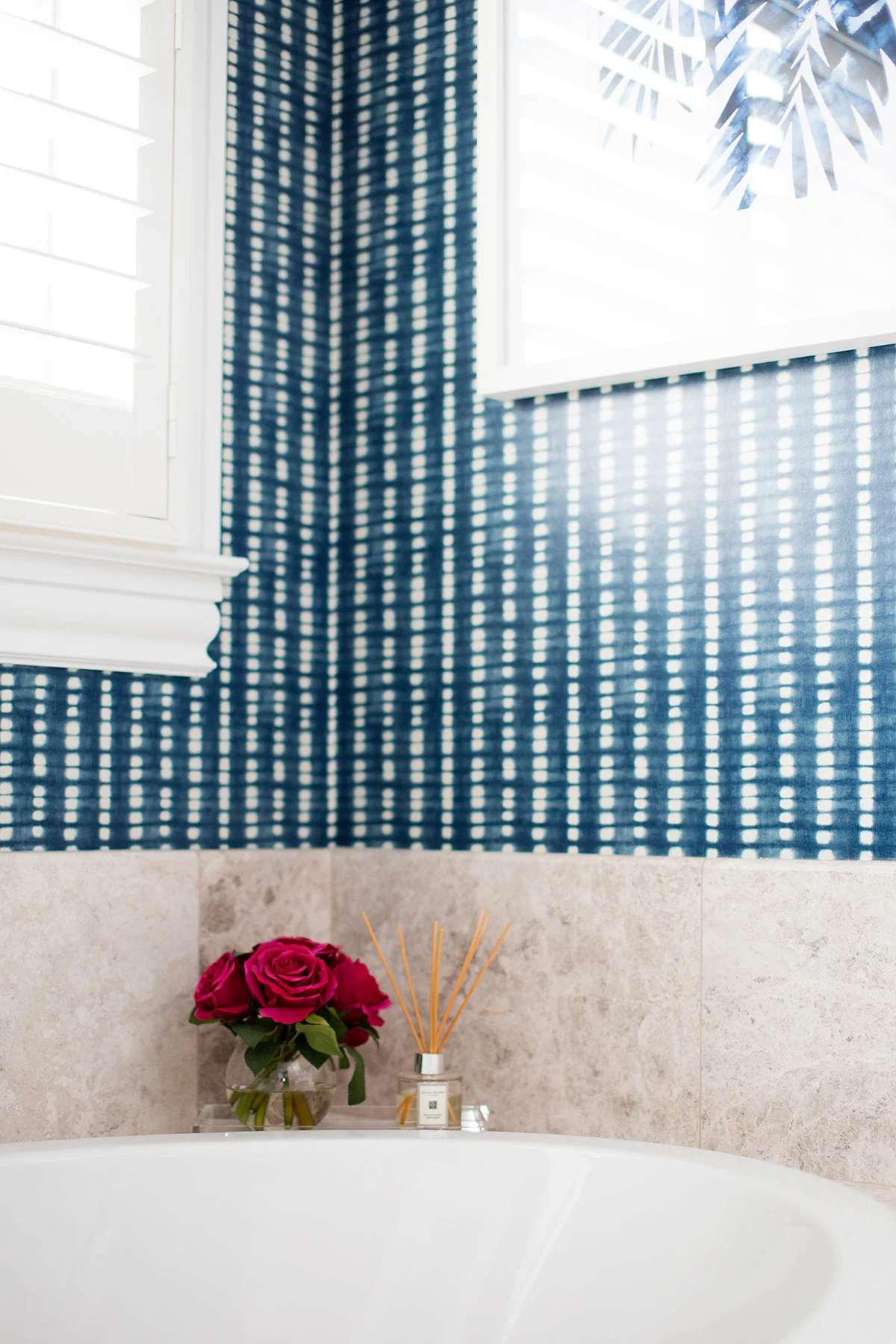 Built in tub in transitional master bathroom with blue and white wallpaper
