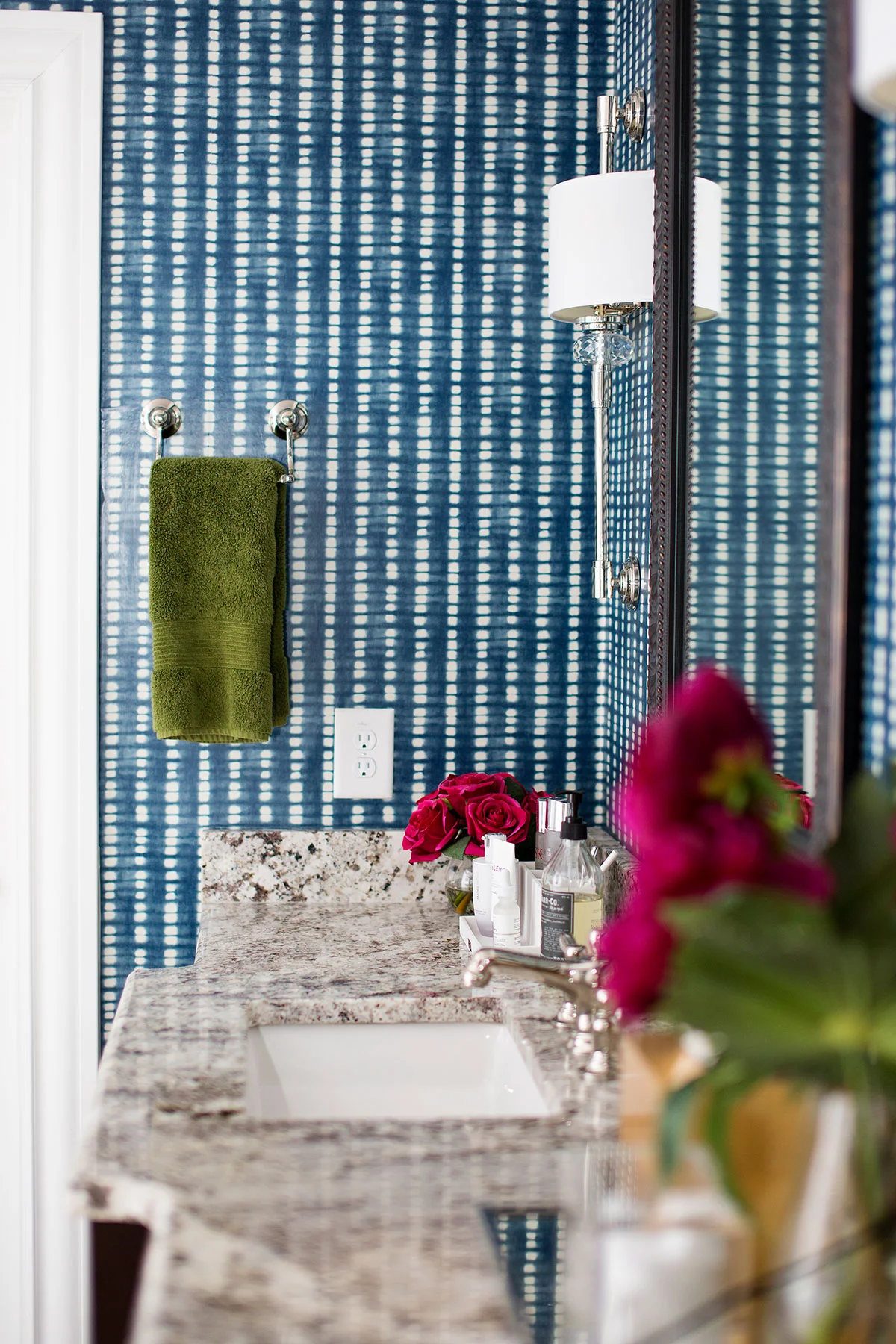 Built in vanity in master bathroom with blue and white wallpaper
