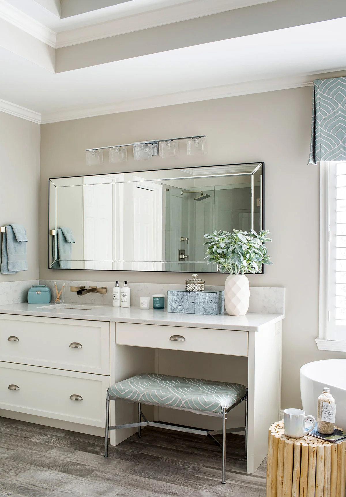 Custom built-in vanity with marble countertop and white cabinetry in master bathroom