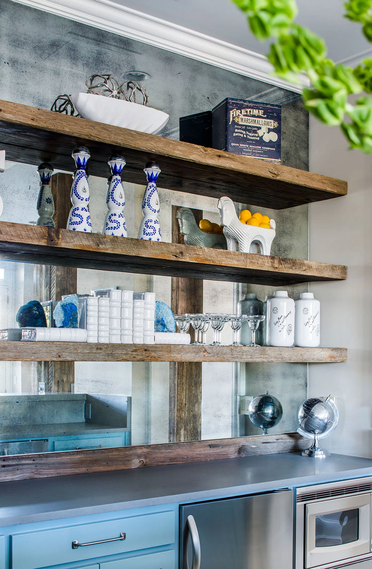 Basement wet bar with floating wood shelves and mirror backsplash