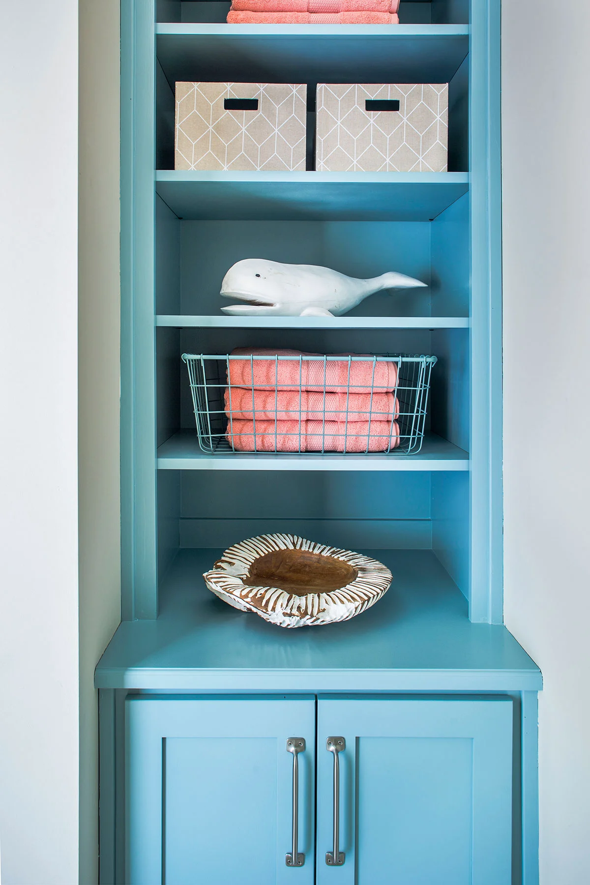 Colorful, coastal bathroom with turquoise cabinetry and brushed nickel hardware