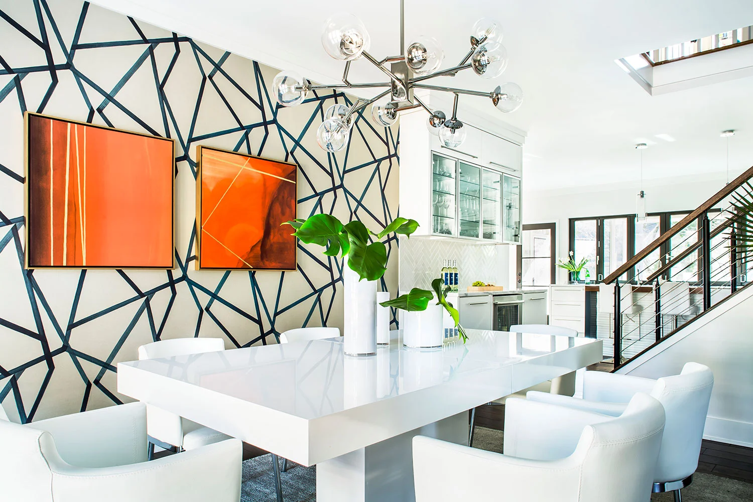 Contemporary dining room with geometric wallpaper, white furniture, and polished nickel chandelier