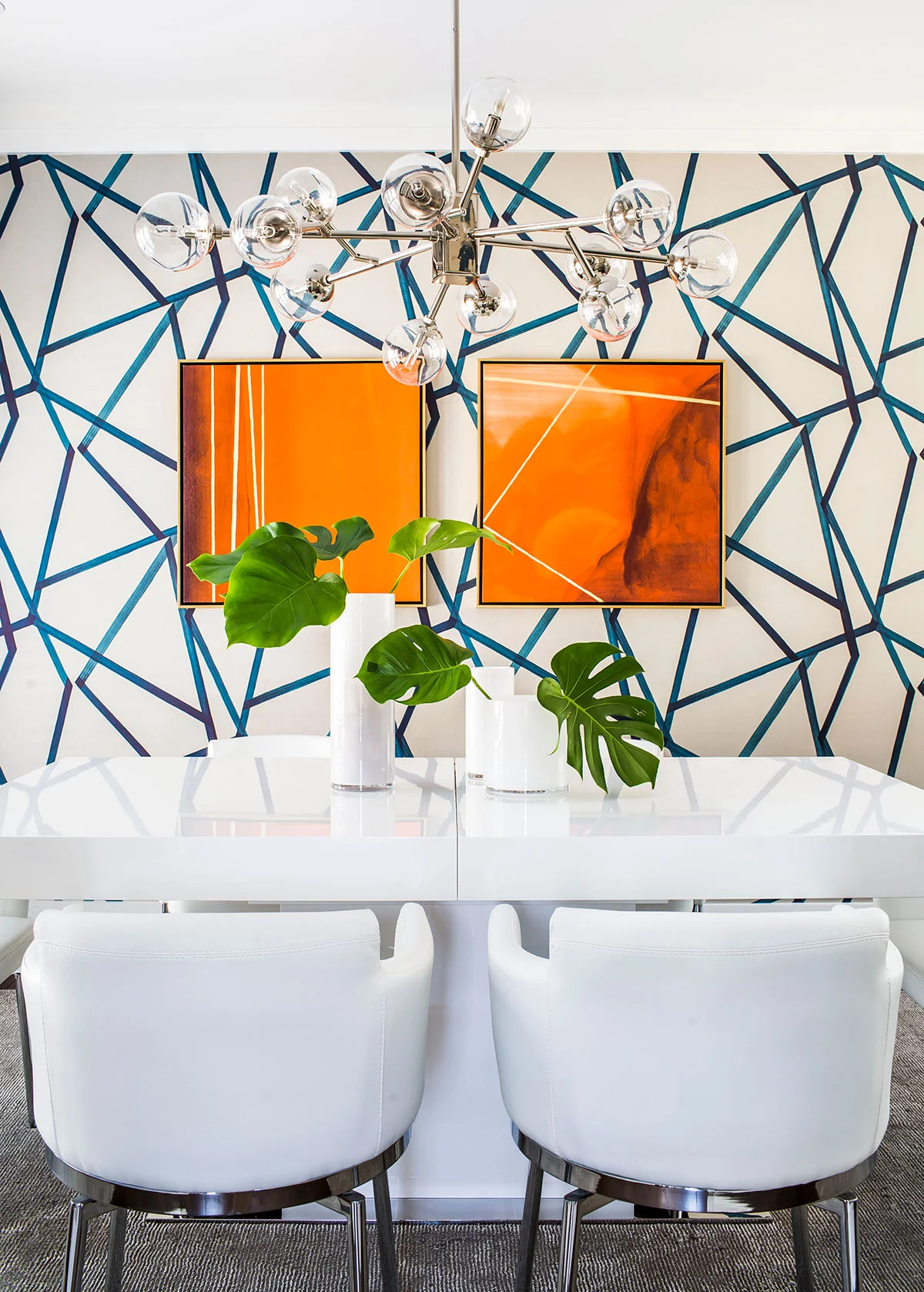 Contemporary dining room with white furniture and geometric wallpapered wall