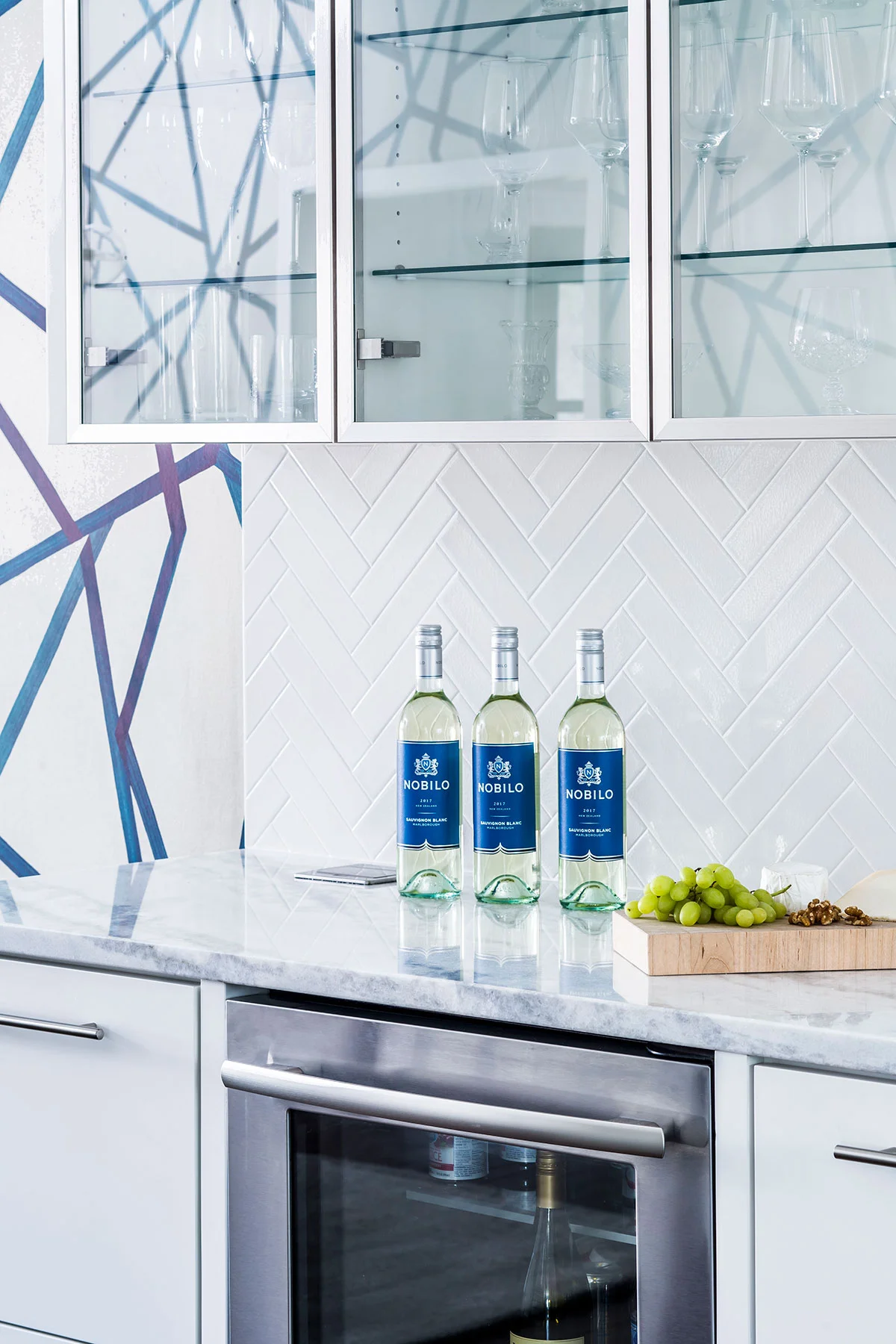 White built-in cabinetry with clear glass doors for storage of glassware
