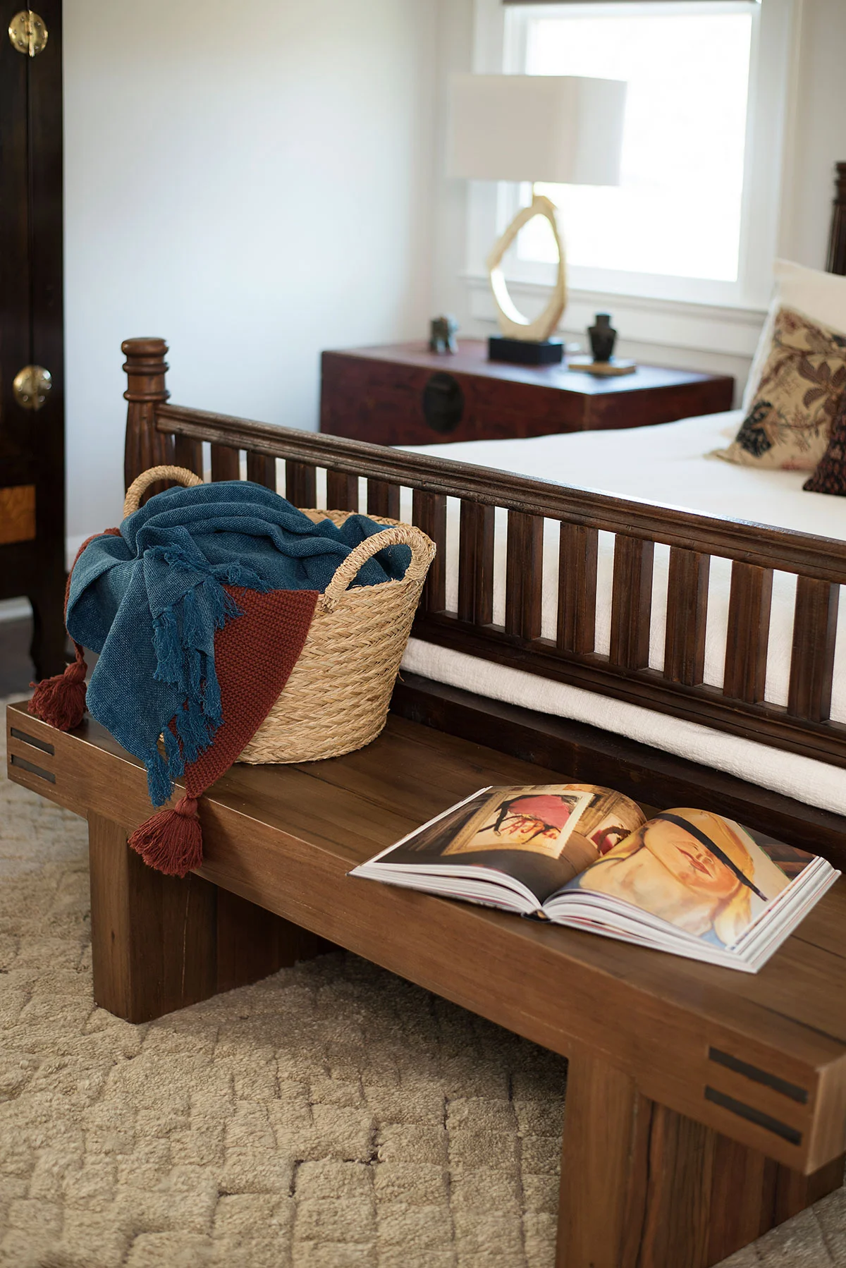 Wood bench at foot of bed in master bedroom
