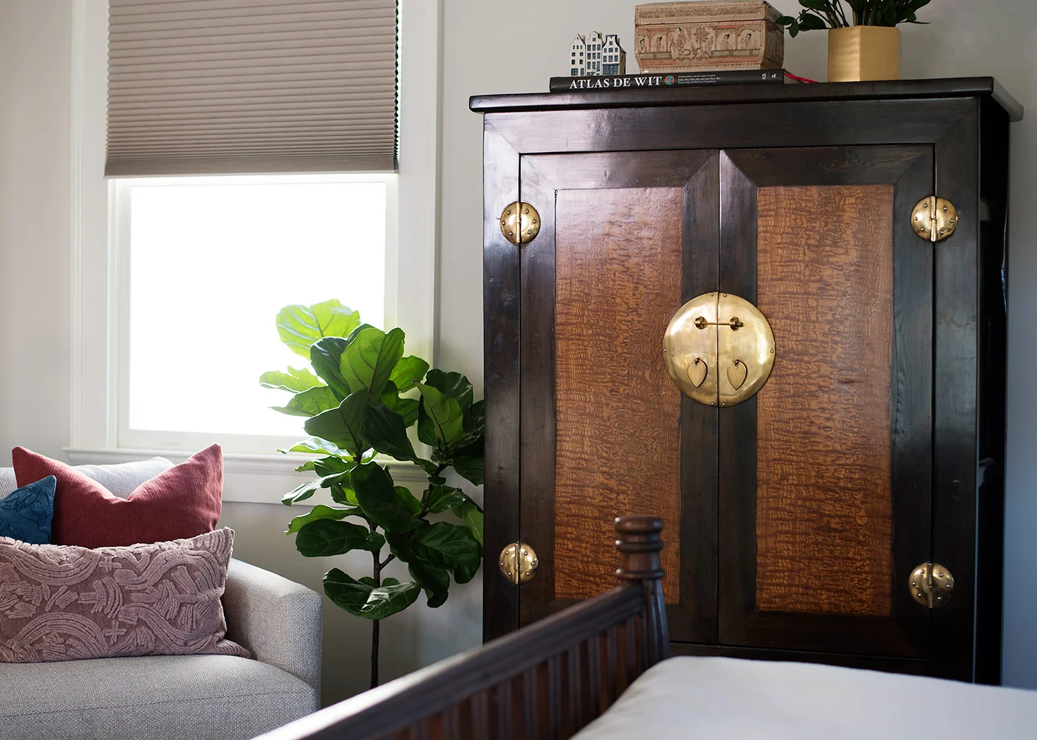 Antique wardrobe with brass hardware in master bedroom
