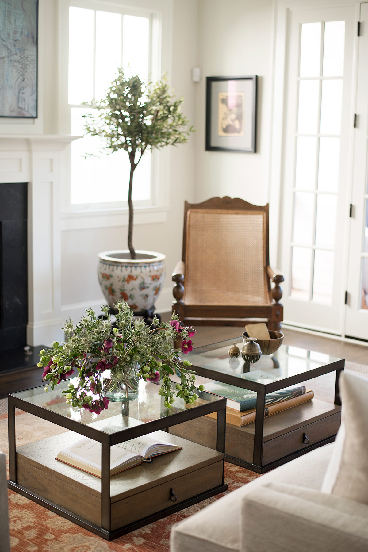 Matching glass coffee tables with books and flowers