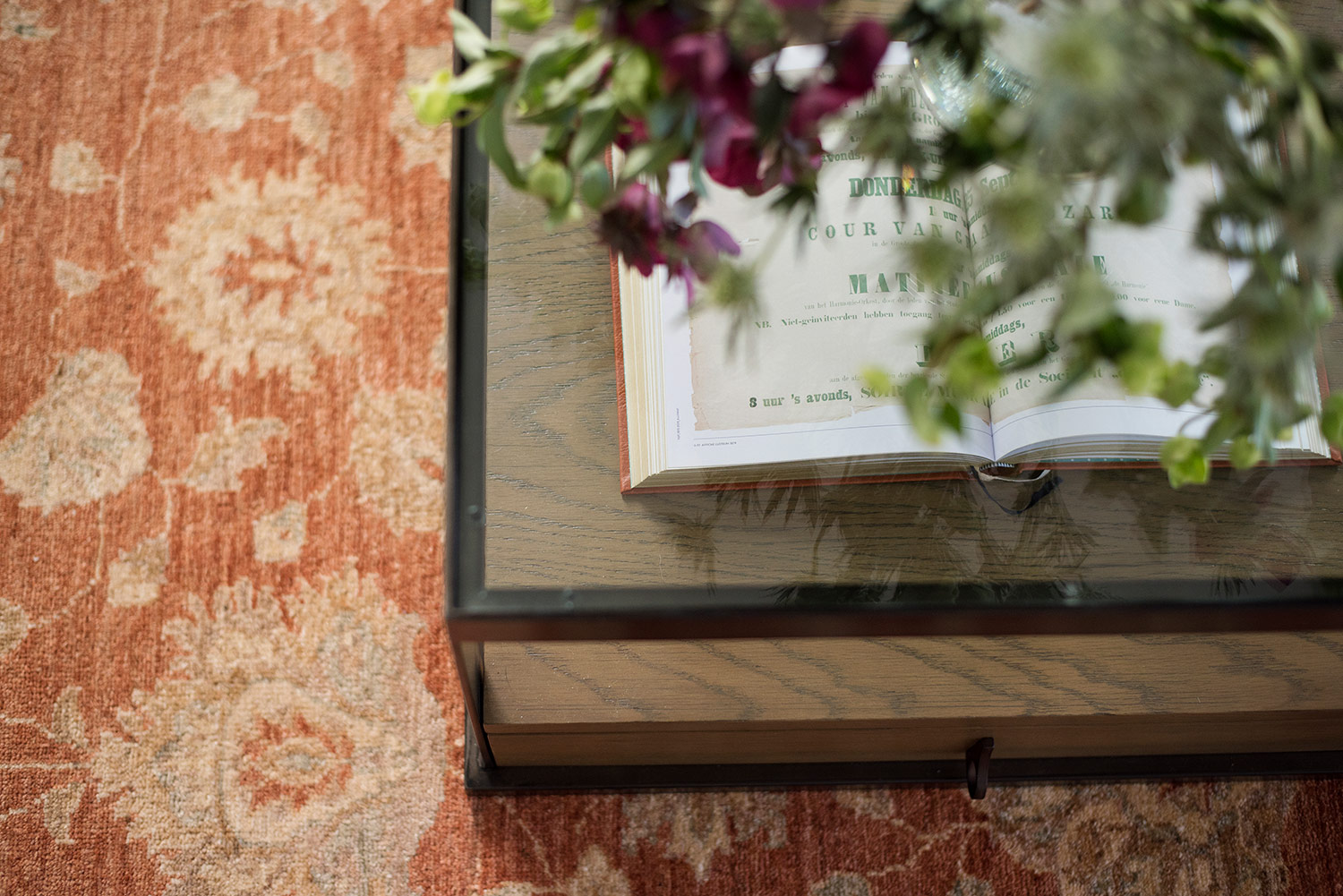 Orange floral rug and antique glass coffee table
