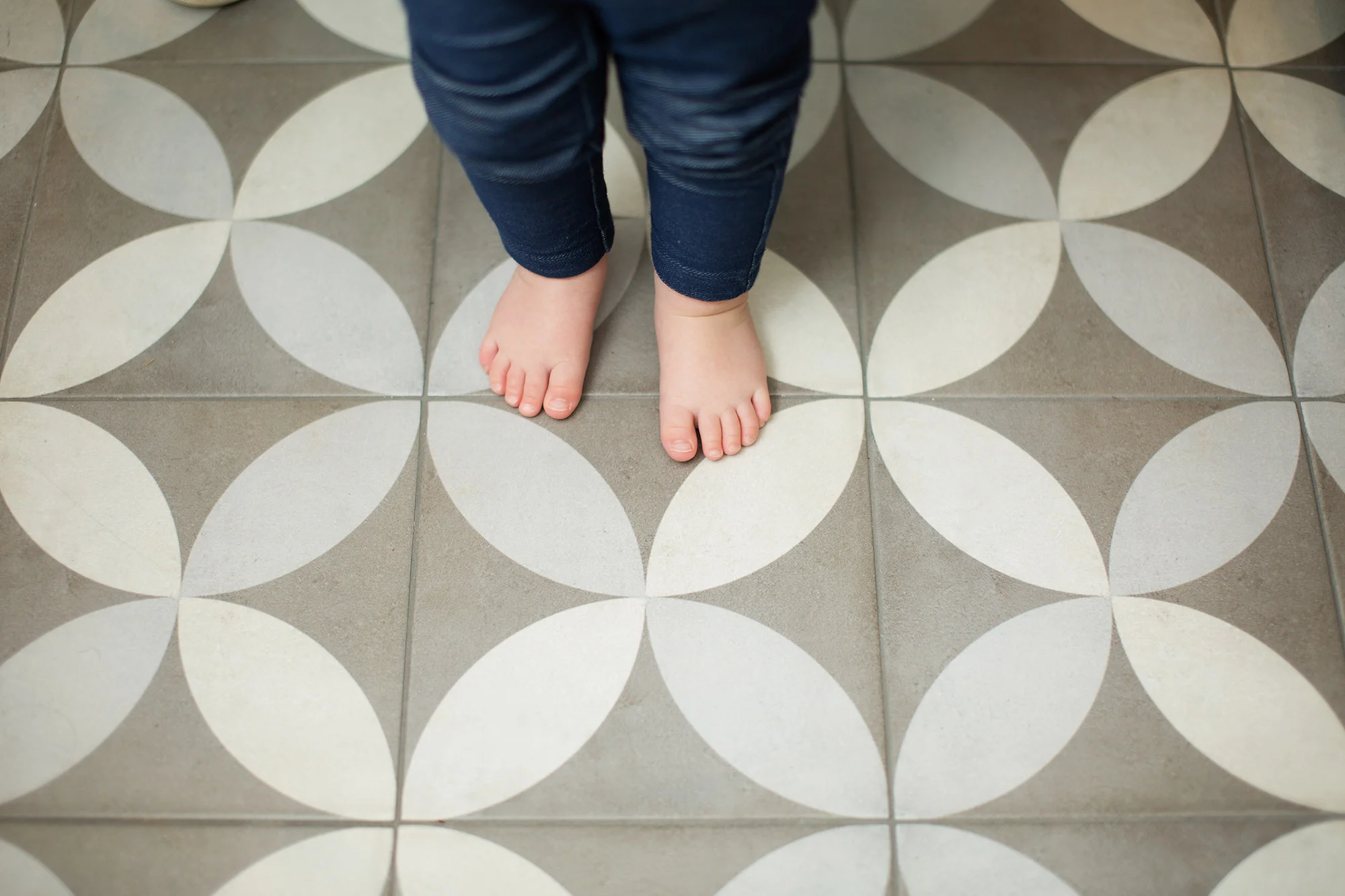 Grey and white patterned floor tile in guest bathroom