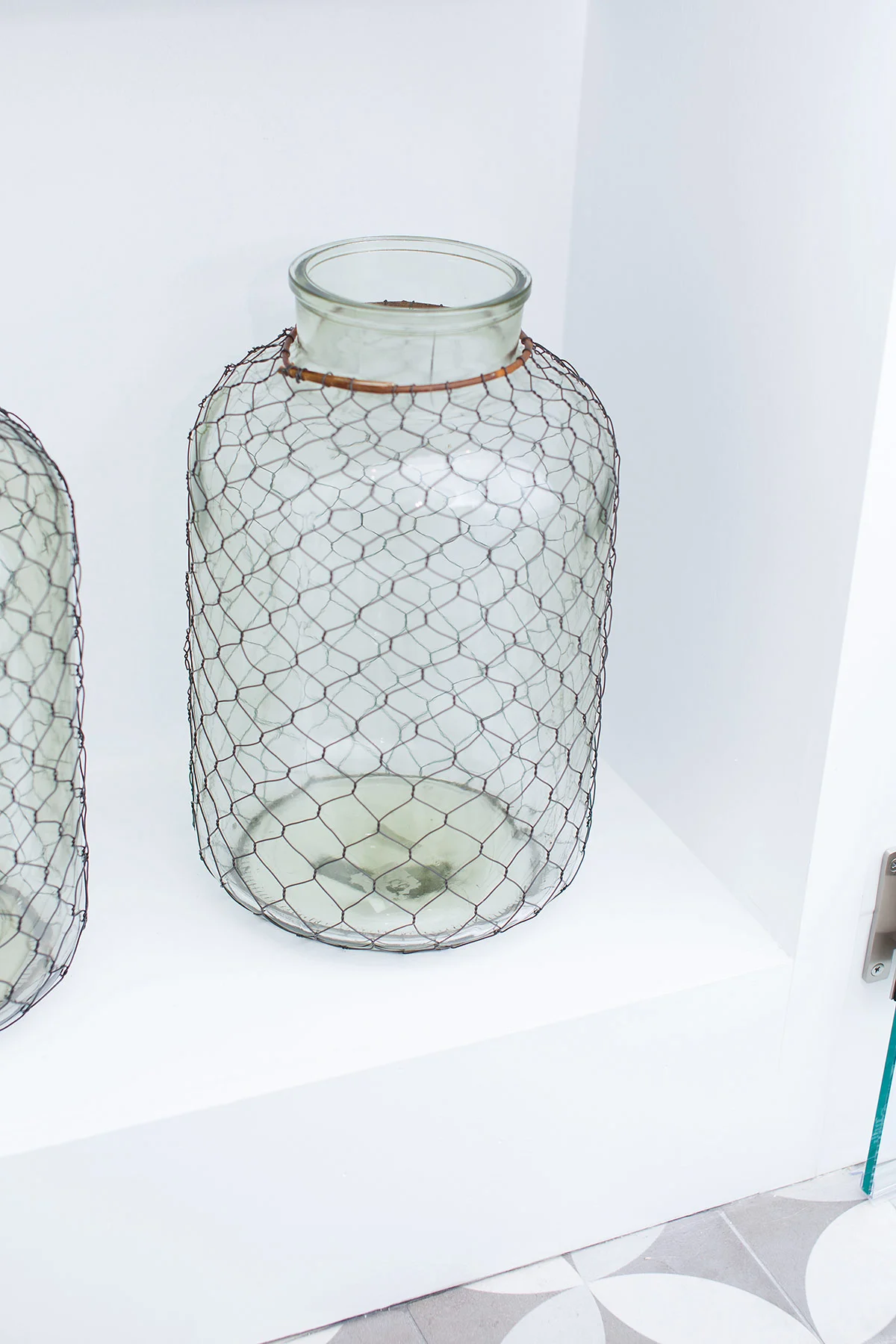 Caged glass jars in coastal guest bathroom