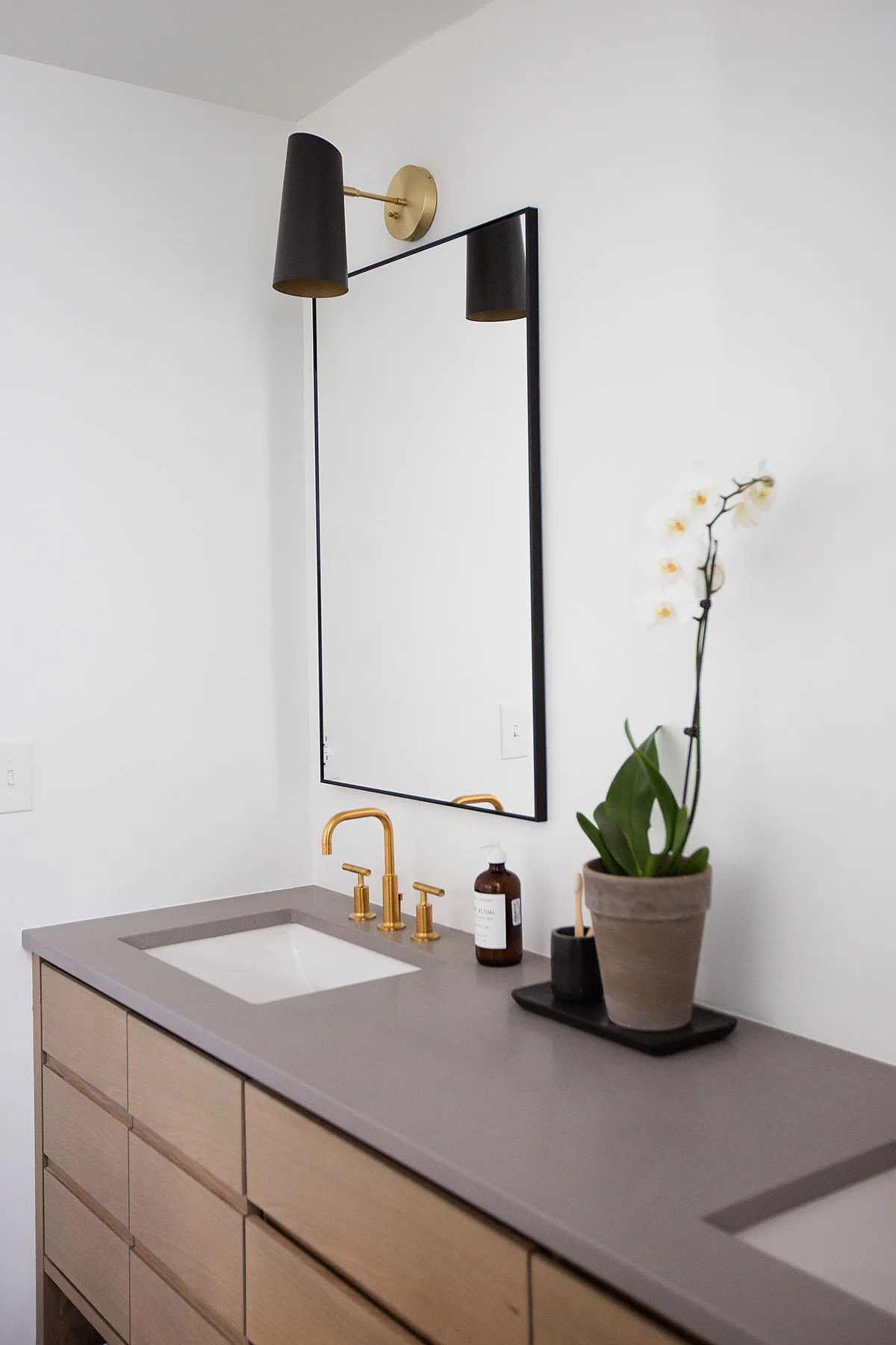 Built-in vanity with grey countertop in midcentury master bathroom