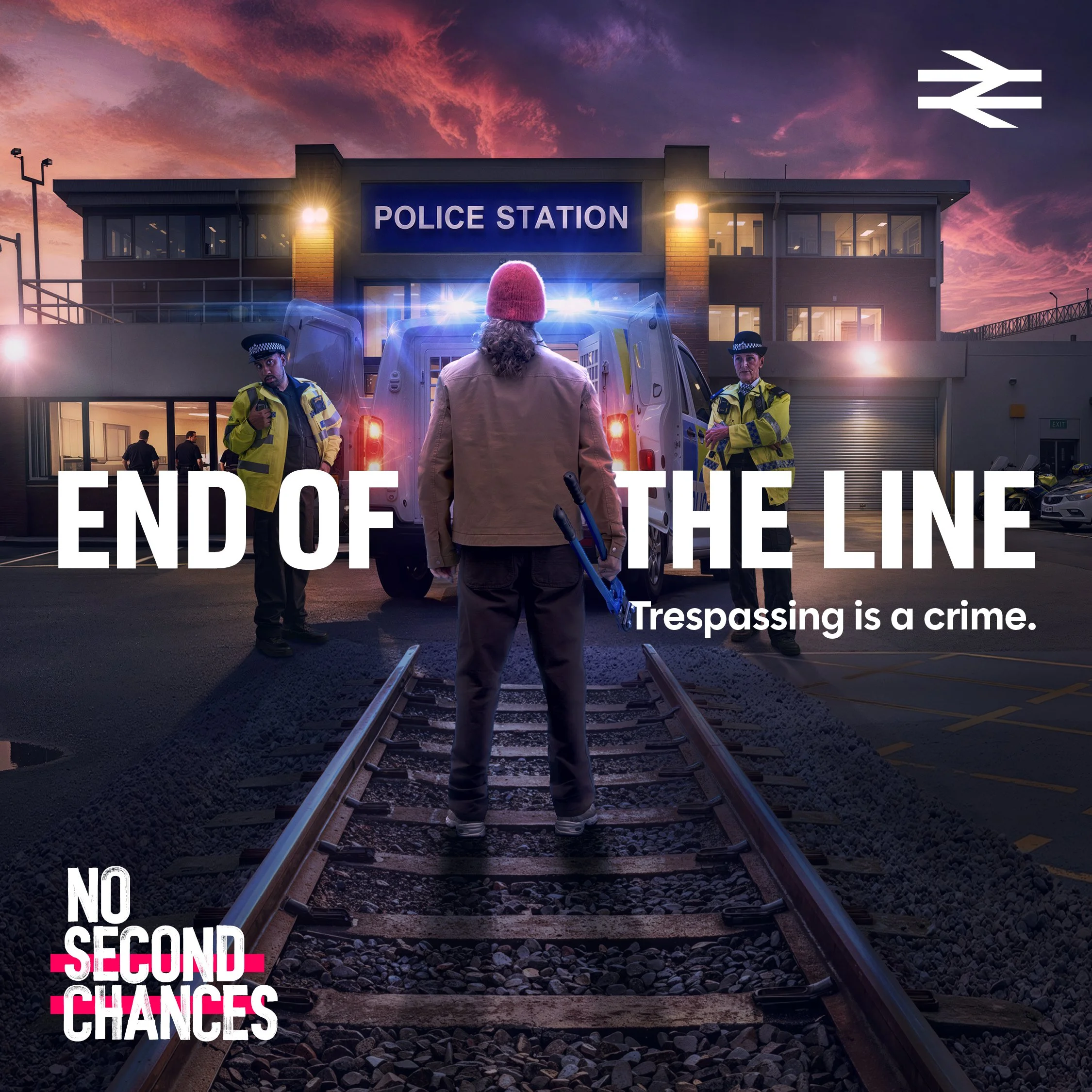 National Rail “End of the Line” advert showing a person on railway tracks facing a police van outside a police station.