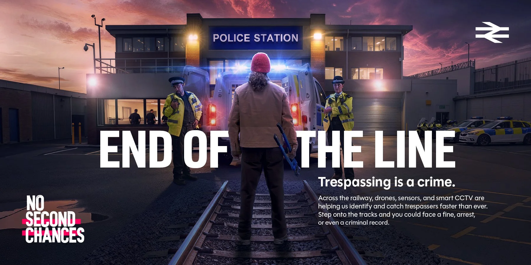 National Rail “End of the Line” advert showing a person on railway tracks facing a police van outside a police station.
