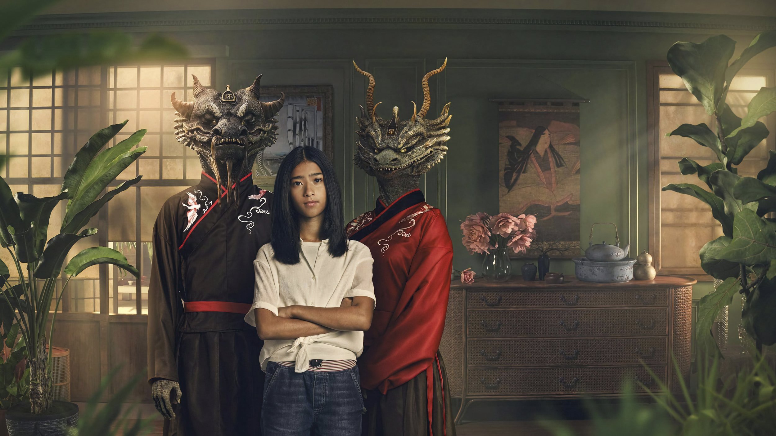 Person with folded arms standing between two dragon-like CGI relatives, from Kai Bastard’s Not Fitting In.