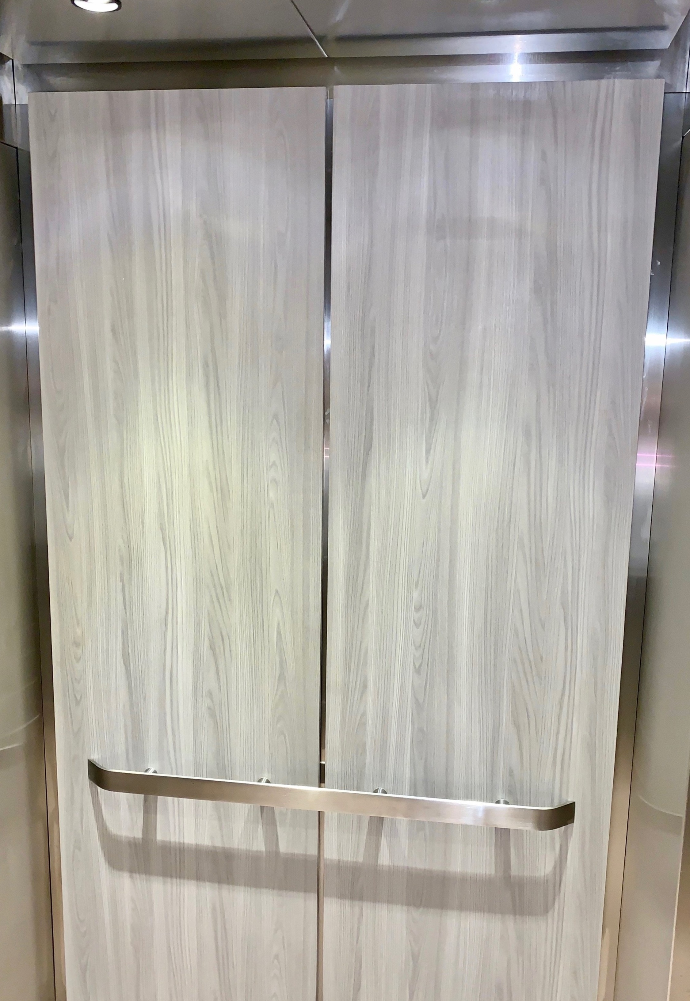 Alto Buckhead - Installed brushed stainless steel ceiling, LED downlights, laminate wall panels, brushed stainless steel reveals with carpet flooring.