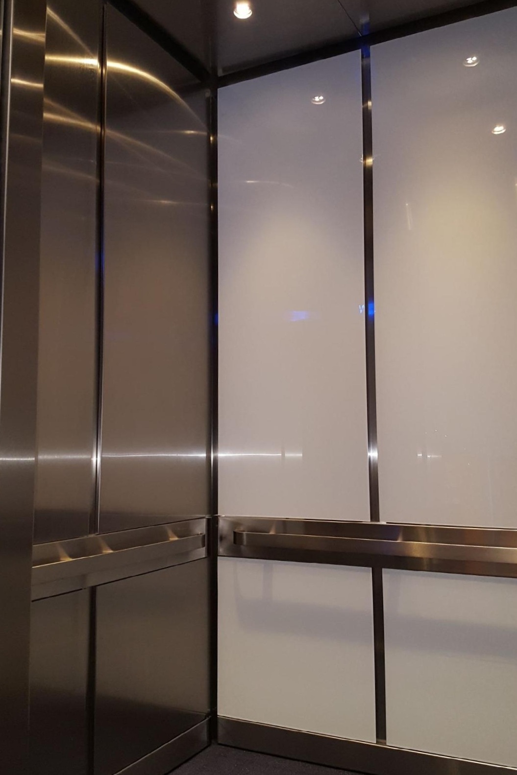 Delta OC1 - Installed brushed stainless steel ceiling, LED downlights, glass wall panels on back wall and brushed stainless steel panels on the side walls with brushed stainless steel reveals.