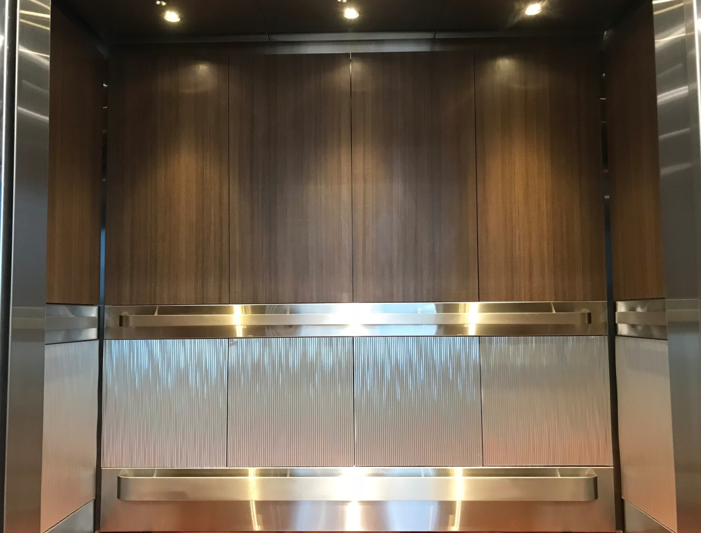 Medical Midtown - Installed brushed stainless steel ceiling, laminate upper wall panels architectural metal wall panels on the bottom and brushed stainless steel reveal package.