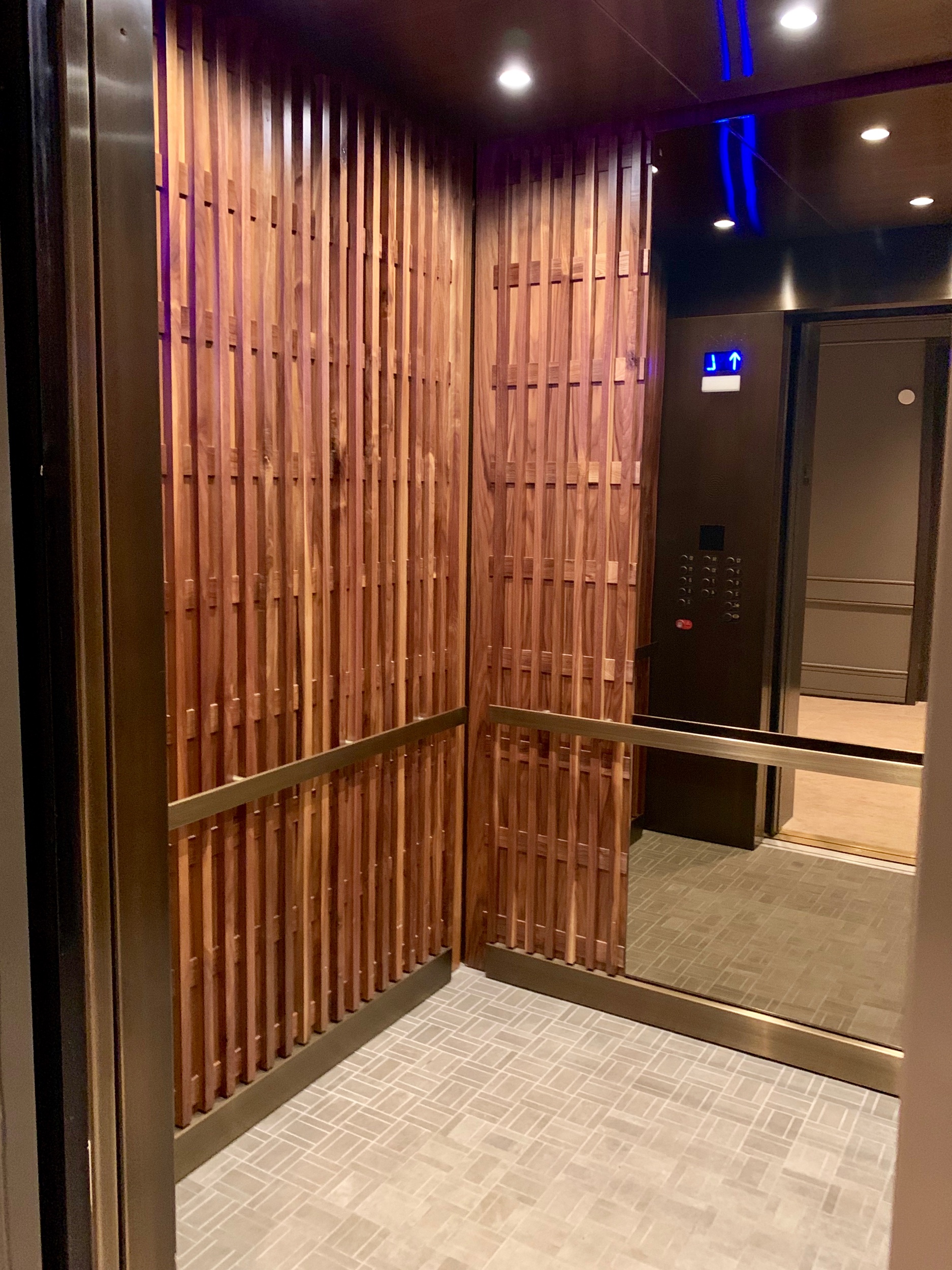 Crown Plaza Atlanta Perimeter at Ravina- Fabricated and installed medium bronze ceiling, handrails and reveal package walnut lattice wall panels and bronze mirror on back wall with carpet flooring.