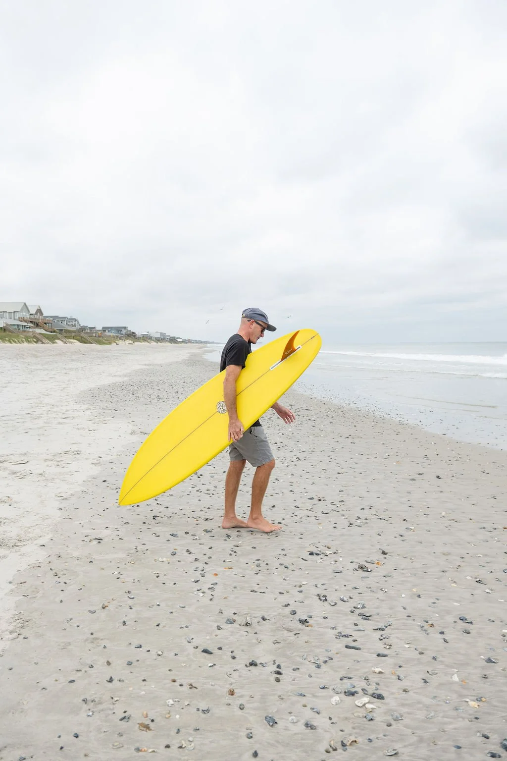 Yellow surf board on it's way to the ocean on Topsail Island