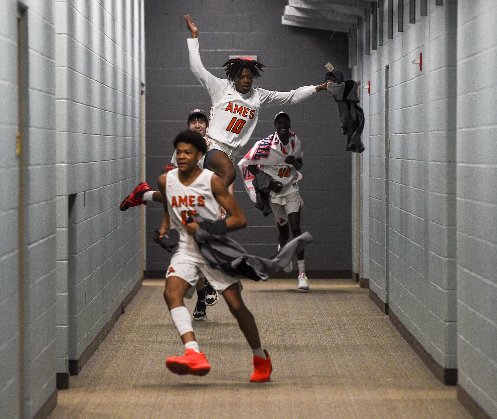 Ames' Tasean Brooks (10) jumps in the air as he and teammates head to the locker room after the Class 4A Iowa high school boys basketball championship game at Wells Fargo Arena on Friday in Des Moines. 
