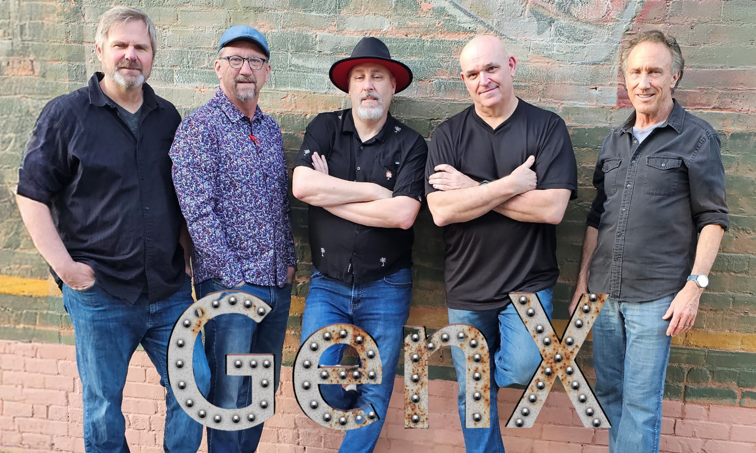 Five men standing in front of a brick wall with a vintage 