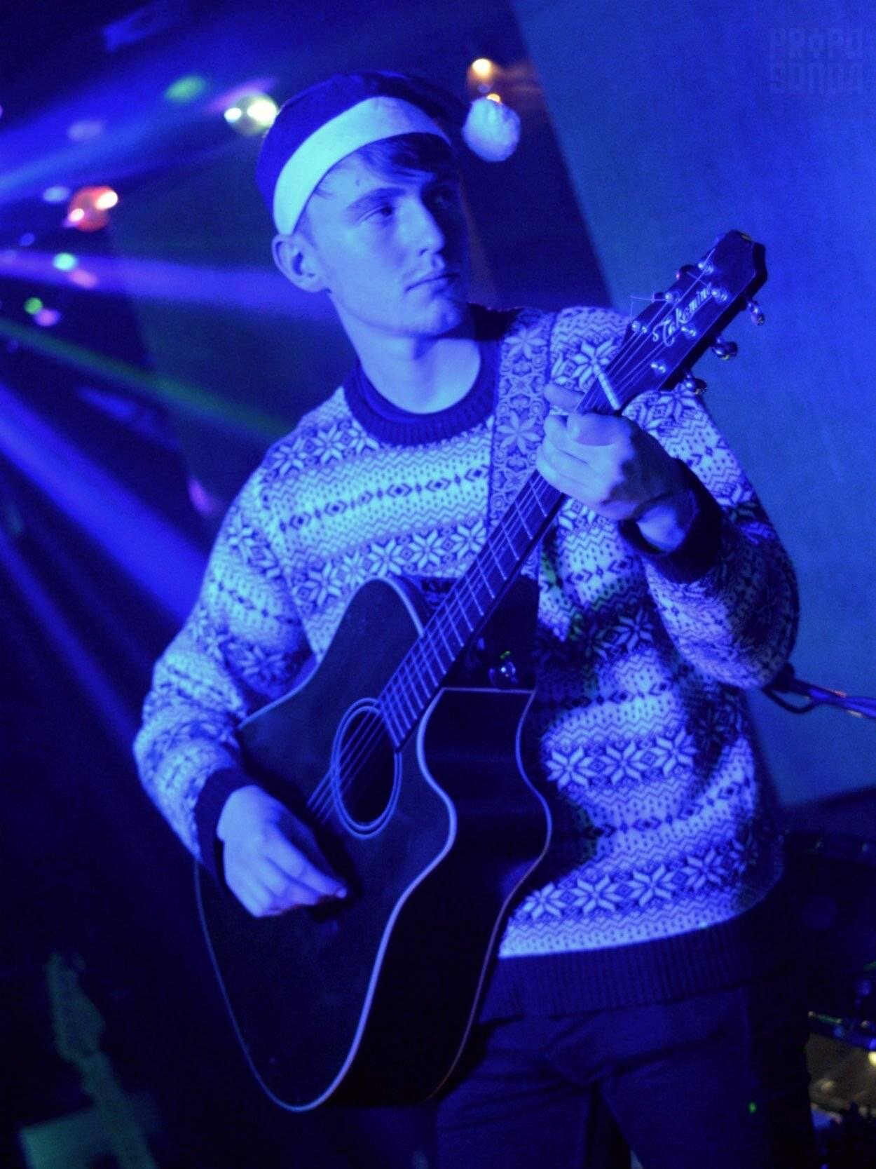 The Magnificent Multi-Instrumentalist Tom Downes, pictured here with a guitar. Taken by Lee Ball.
