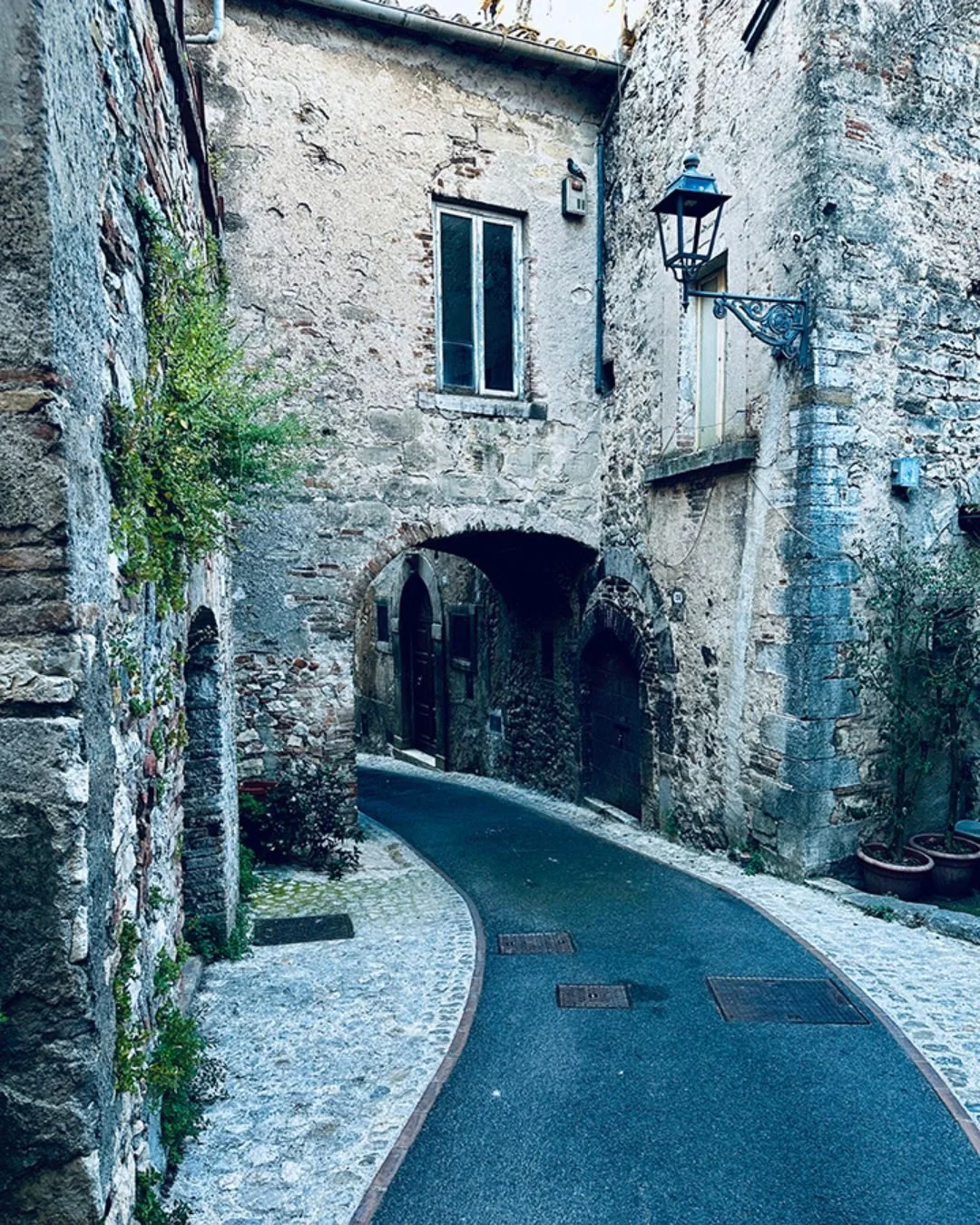Old stone buildings and a winding path in Amelia, Italy.
