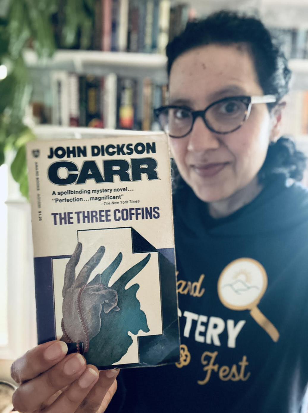 Gigi Pandian holding a paperback copy of THE THREE COFFINS (aka THE HOLLOW MAN) by John Dickson Carr.
