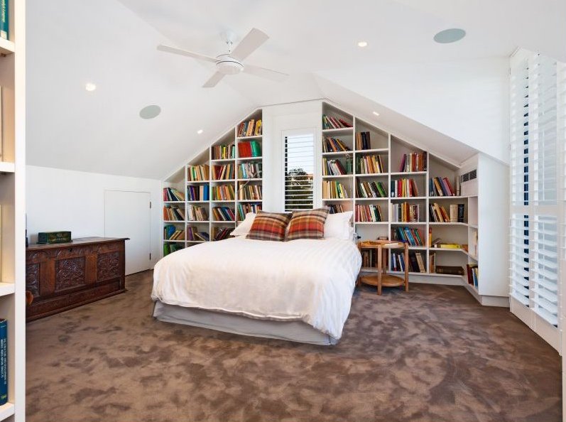  Bedroom with pitched ceiling, bookshelf built in behind a bed  