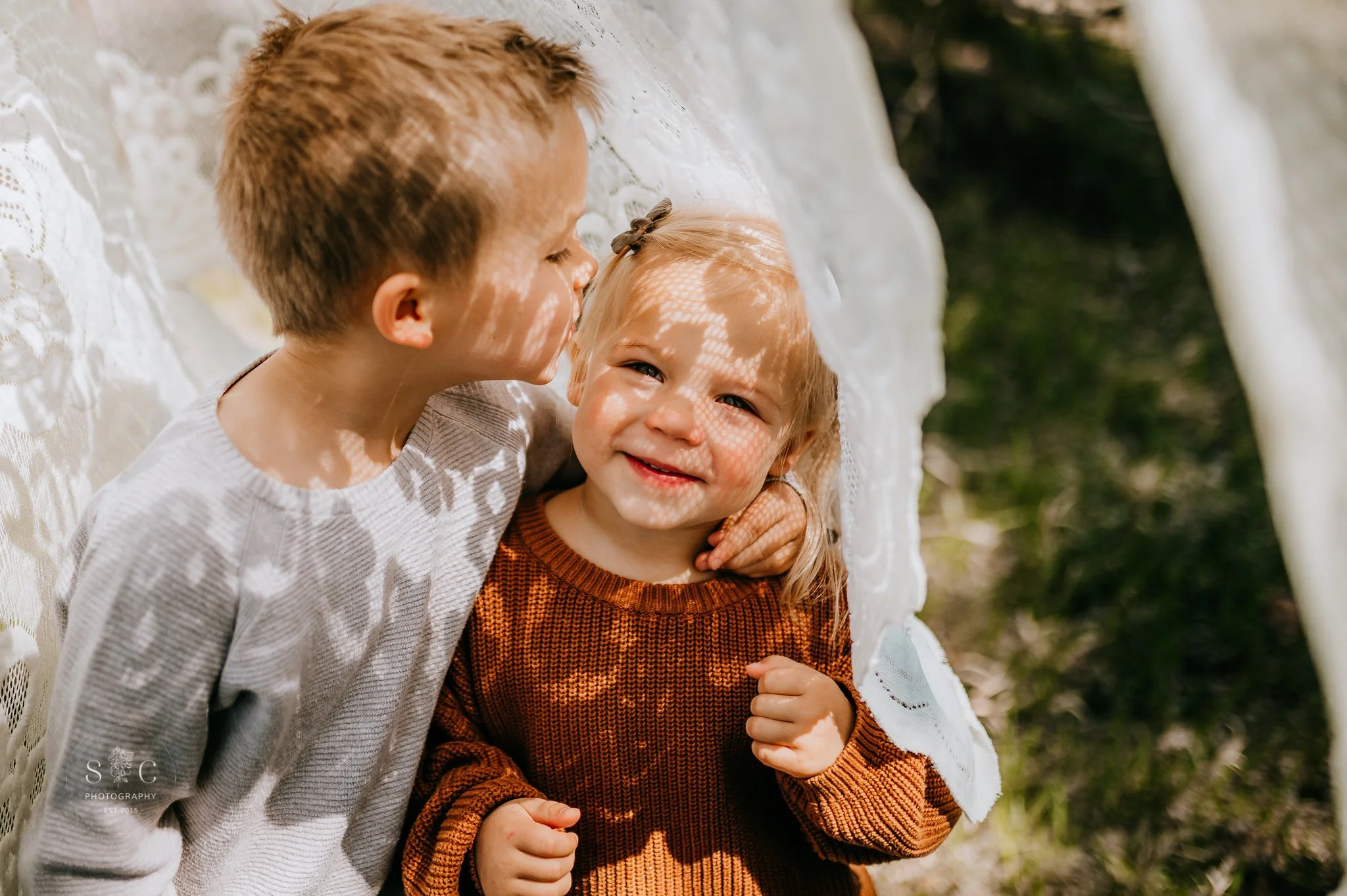 Siblings laughing together during spring mini session in Dickinson North Dakota