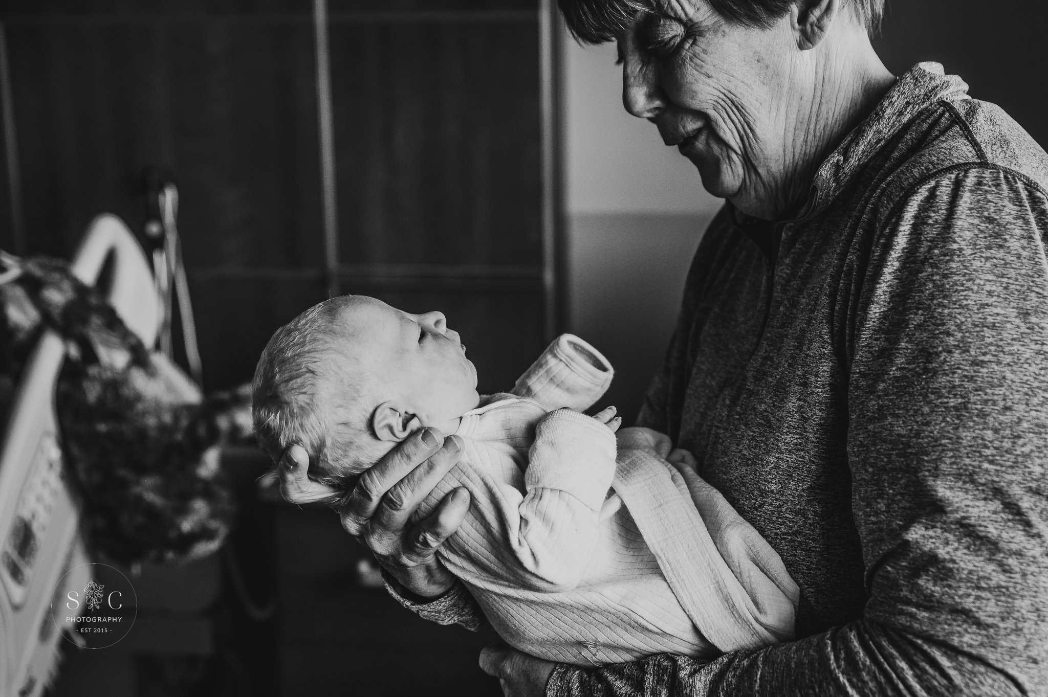 Grandparent meeting newborn for the first time during a Fresh 48 session in Dickinson, ND.