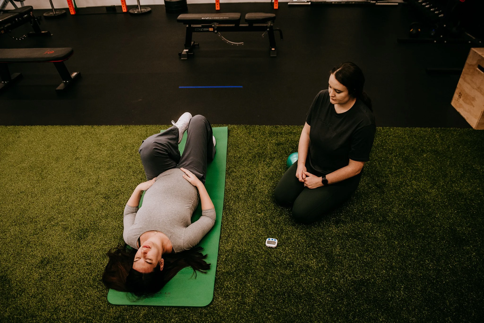 Perinatal fitness trainer coaching a third-trimester client through intentional movement and breathing techniques in Bismarck, North Dakota