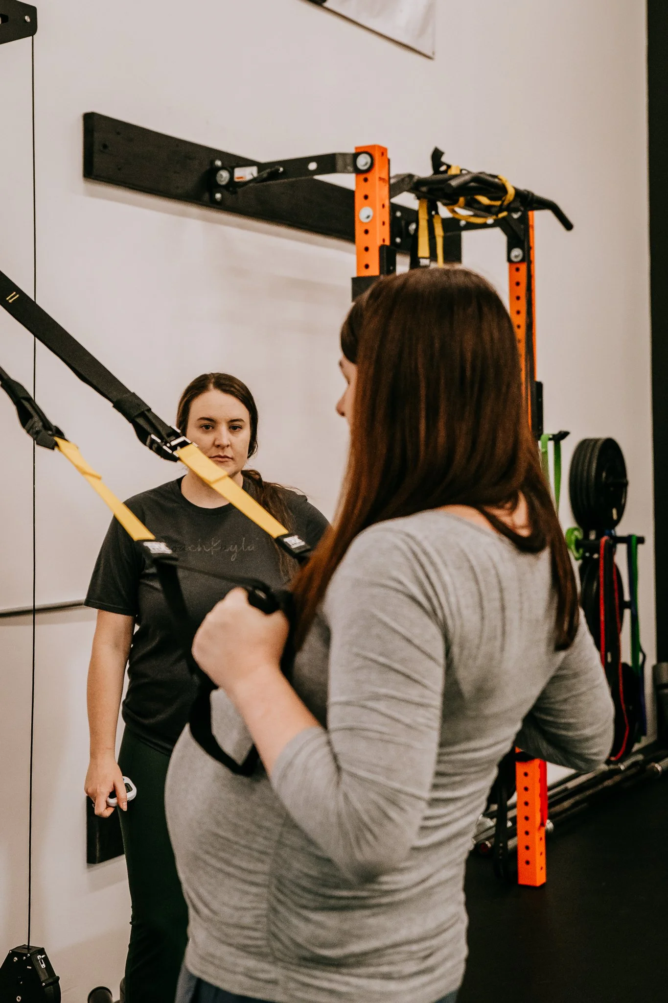 Third-trimester pregnant woman doing gentle movement exercises with a certified prenatal fitness coach in Bismarck, ND