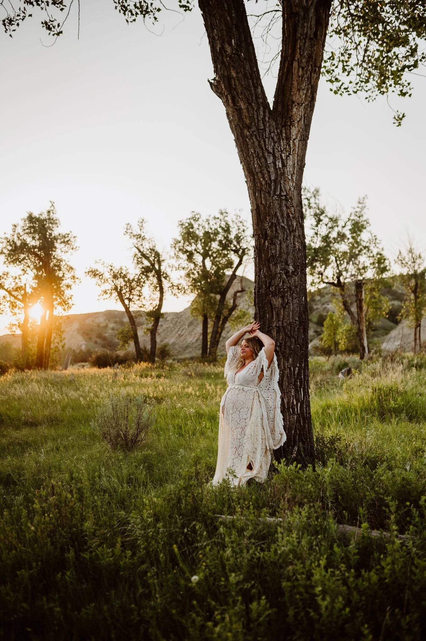 Pregnant woman in white lace dress at golden hour, Light and Lace mini sessions Dickinson ND