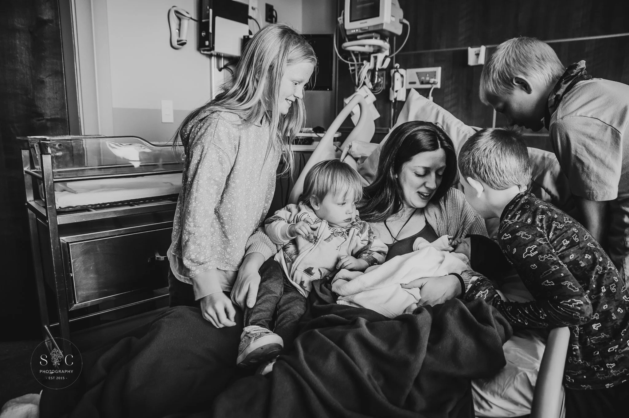 Sibling meeting newborn baby for the first time during a Fresh 48 hospital session in North Dakota.