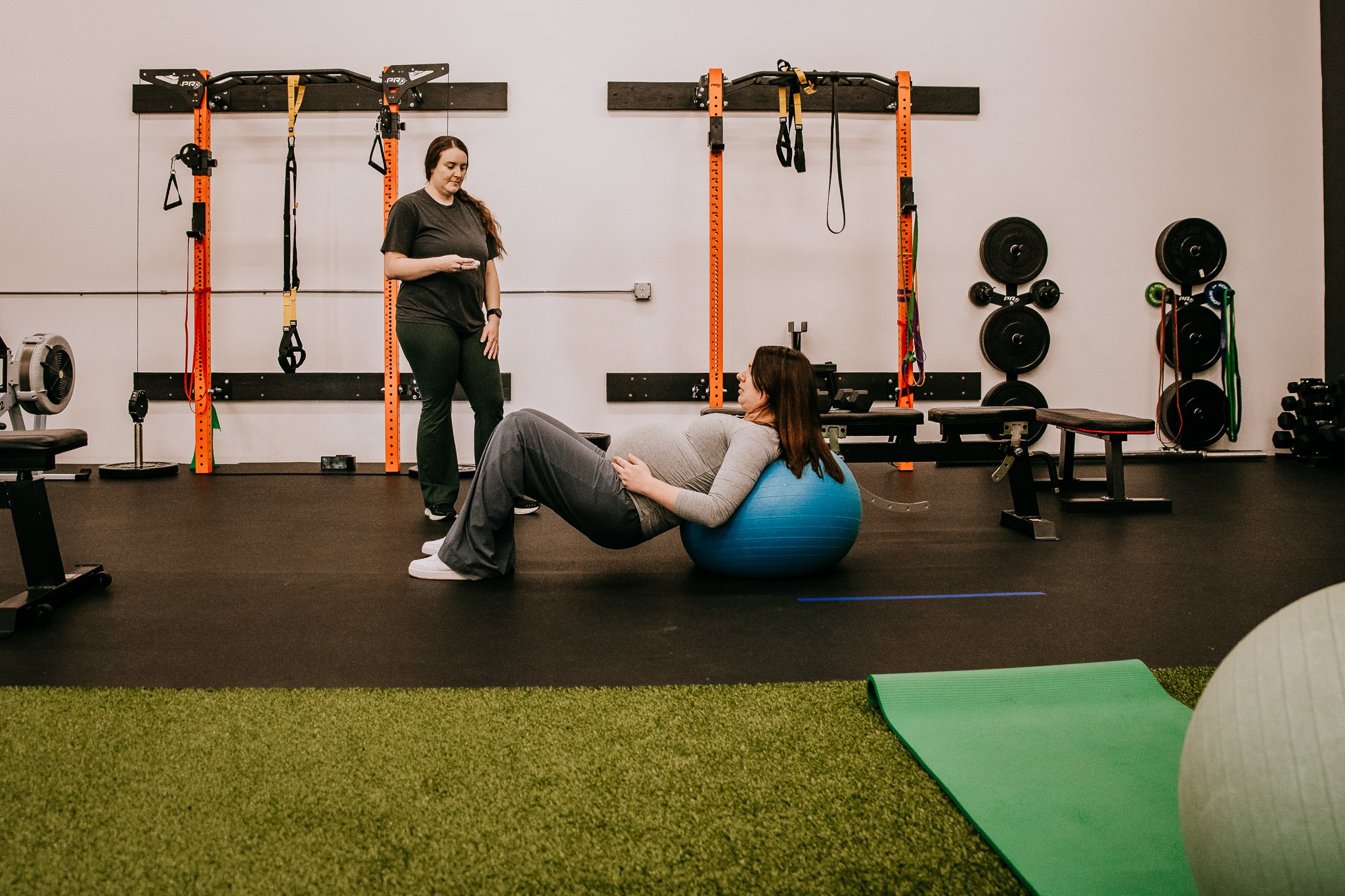 Coach Kayla T., certified prenatal and postnatal corrective exercise specialist, working with a pregnant client in Bismarck, ND