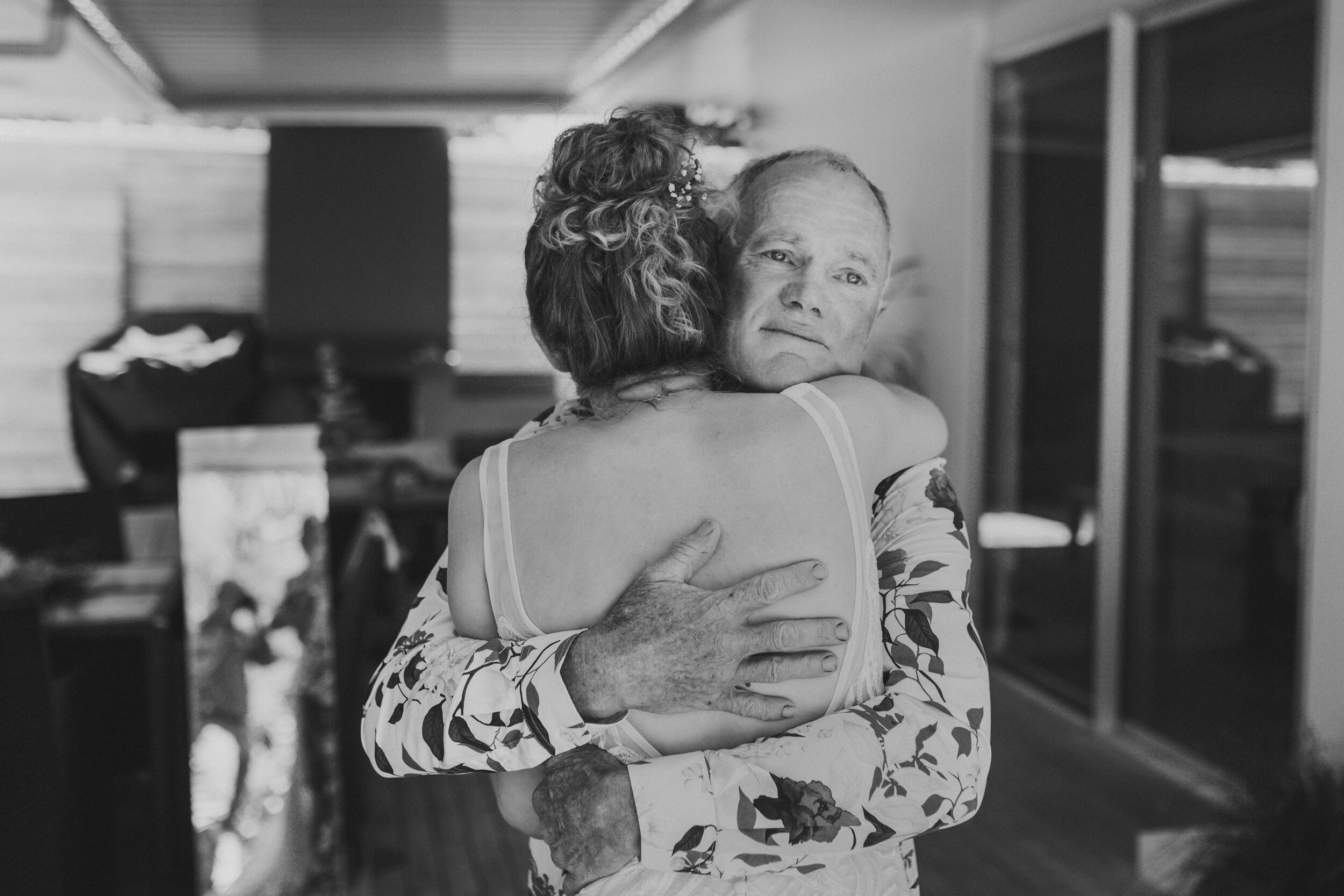 Father hugging bride closely