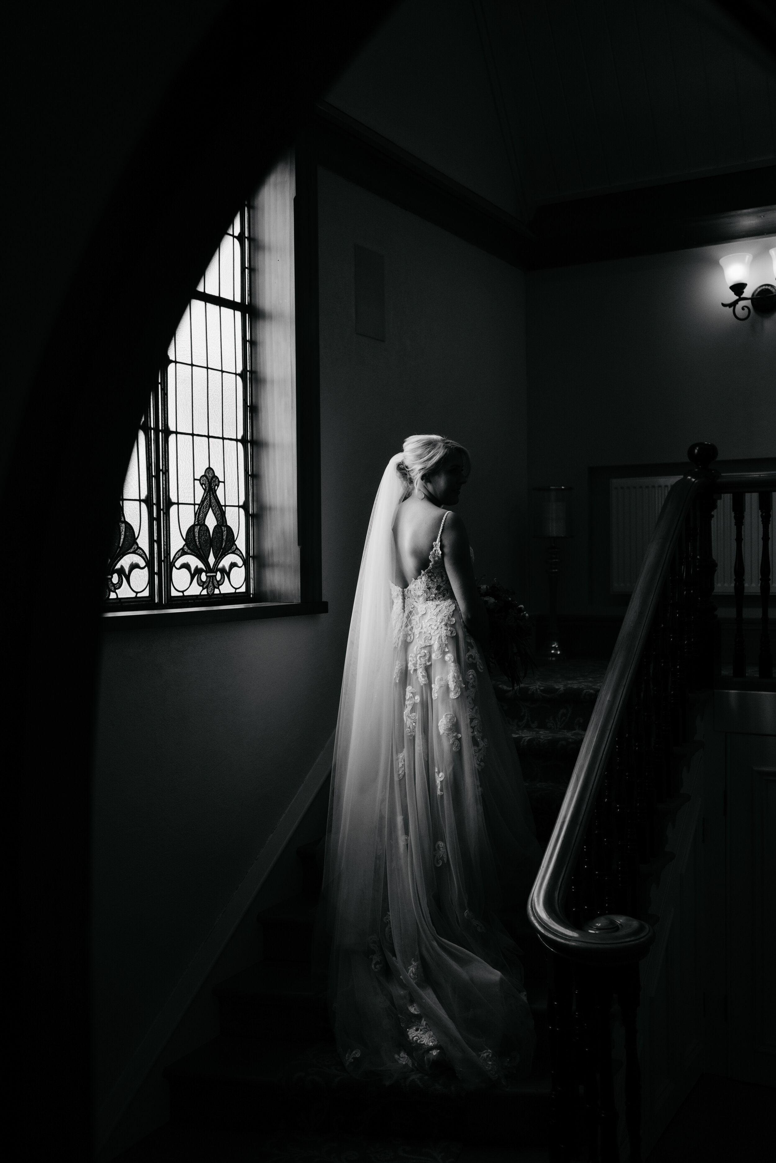 Black and white portrait of bride on staircase