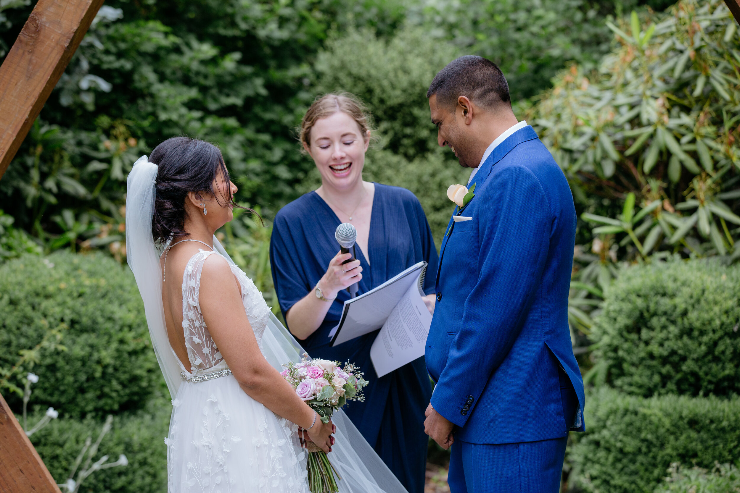 Bride, Groom and Celebrant laughing over microphone issues