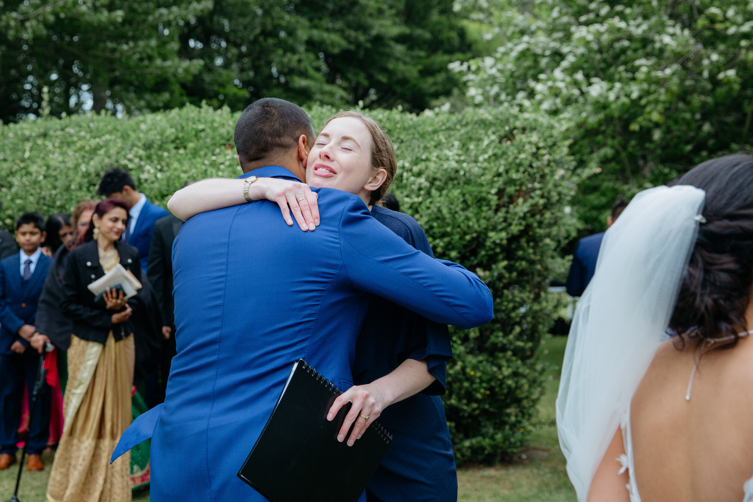 Celebrant hugging groom after New Zealand wedding ceremony at Pemberton Gardens
