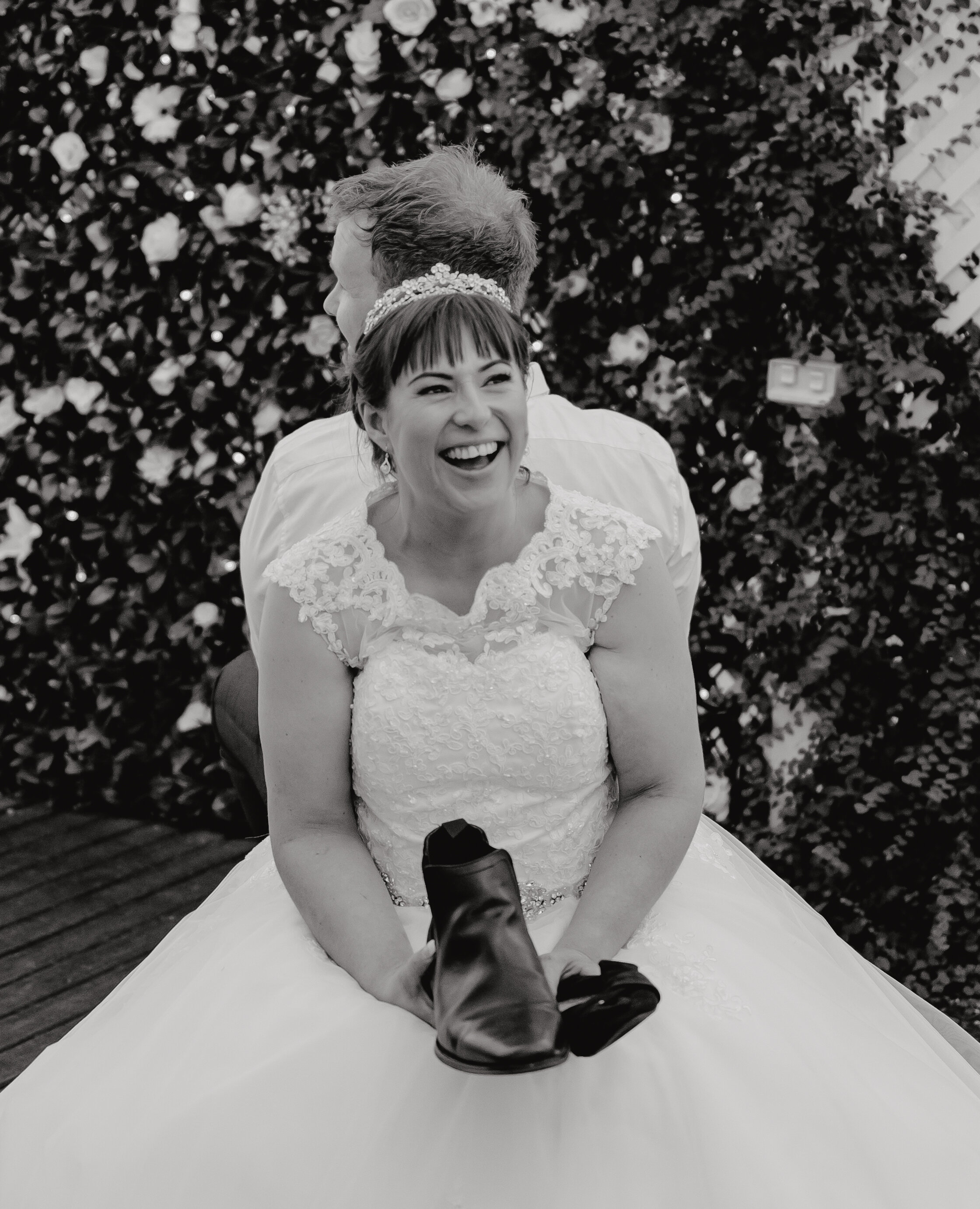 Bride laughing during 'The Shoe Game' at wedding reception