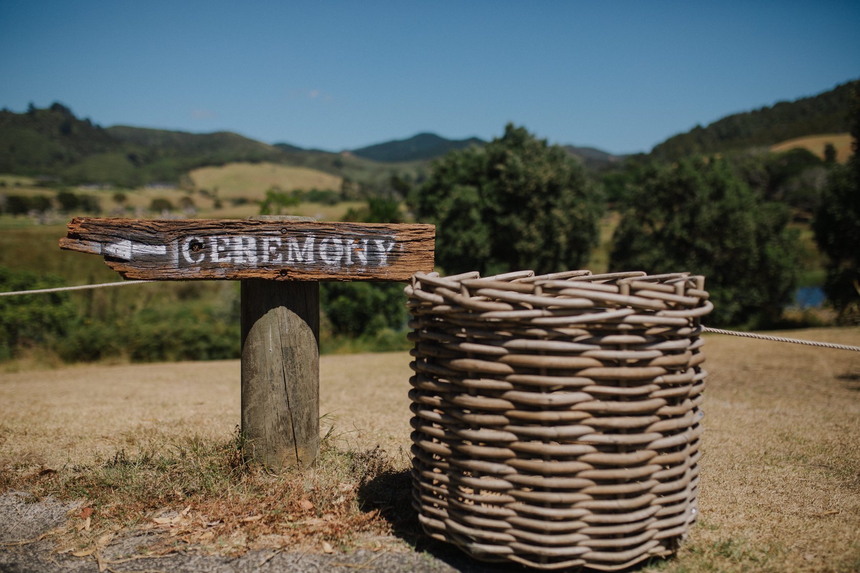 Rustic ceremony signage with woven wooden basket