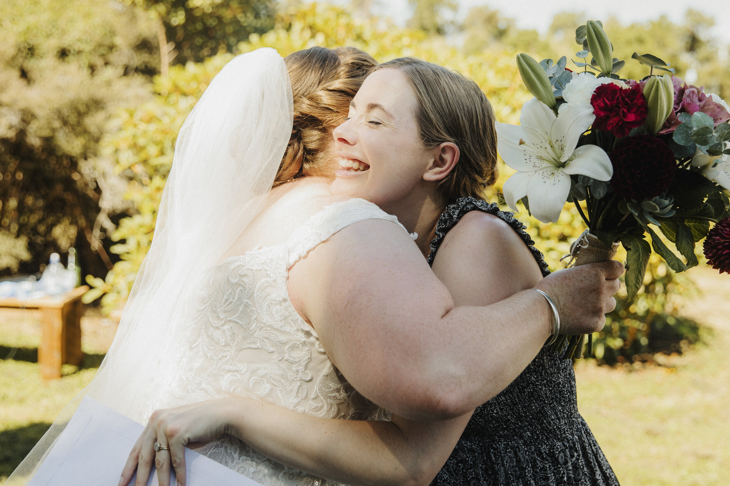 Celebrant hugging bride